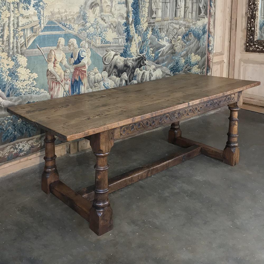 19th century country French dining table was handcrafted from solid, thick planks of old-growth oak to last for centuries, and features nicely turned legs connected with a classic 