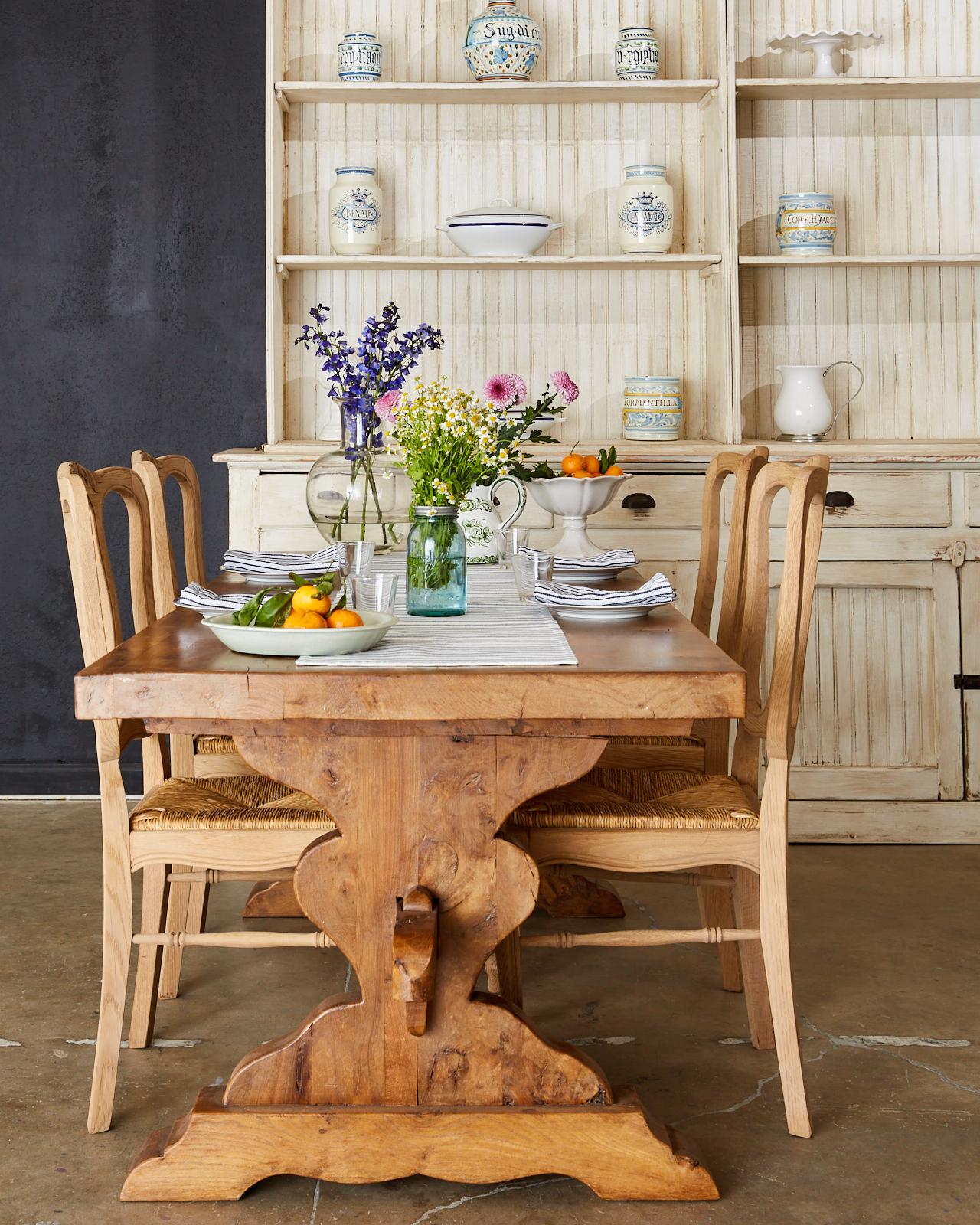 Magnificent 19th century country French farmhouse dining table crafted from Elm timbers. The trestle style table features a 2.25 inch thick plank top showcasing the amazing elm grain patterns with burls and knots. The thick top is supported by