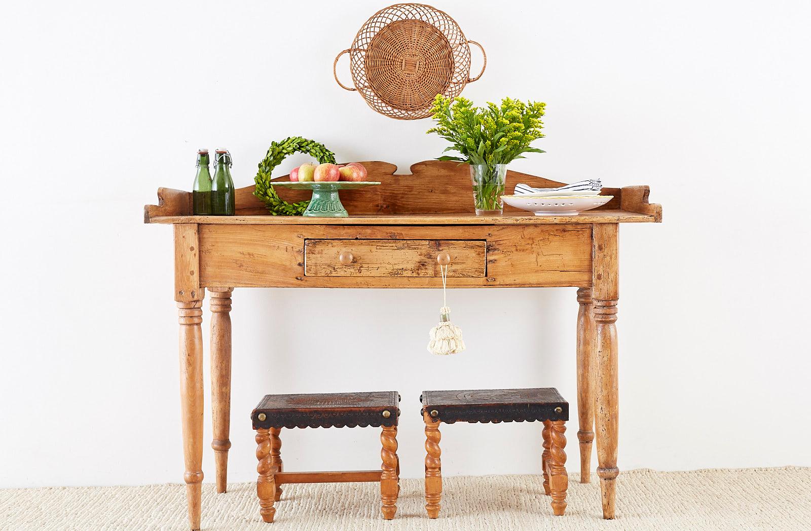 Rustic 19th century country French farmhouse pine server, sideboard or work table. Features a wood peg joinery construction with a beautifully distressed, aged patina on the pine. The top has a shaped, galleried edge in a washstand style. Fronted by