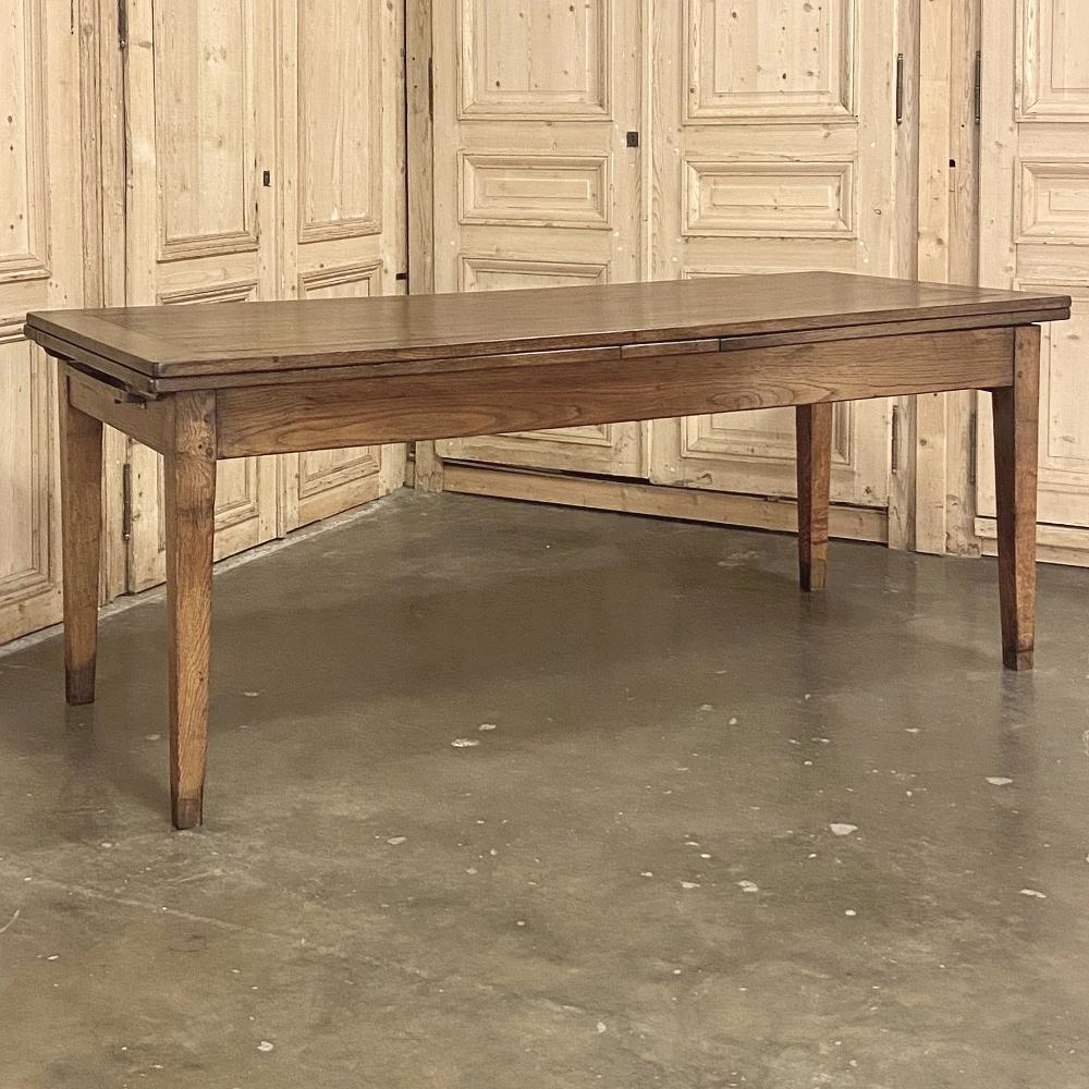 19th century Country French fruitwood draw-leaf banquet table is a clever design, with a main surface large enough to easily seat 6 or even 8 comfortably, but with two massive concealed leaves that when drawn out create a surface over 12 feet long!