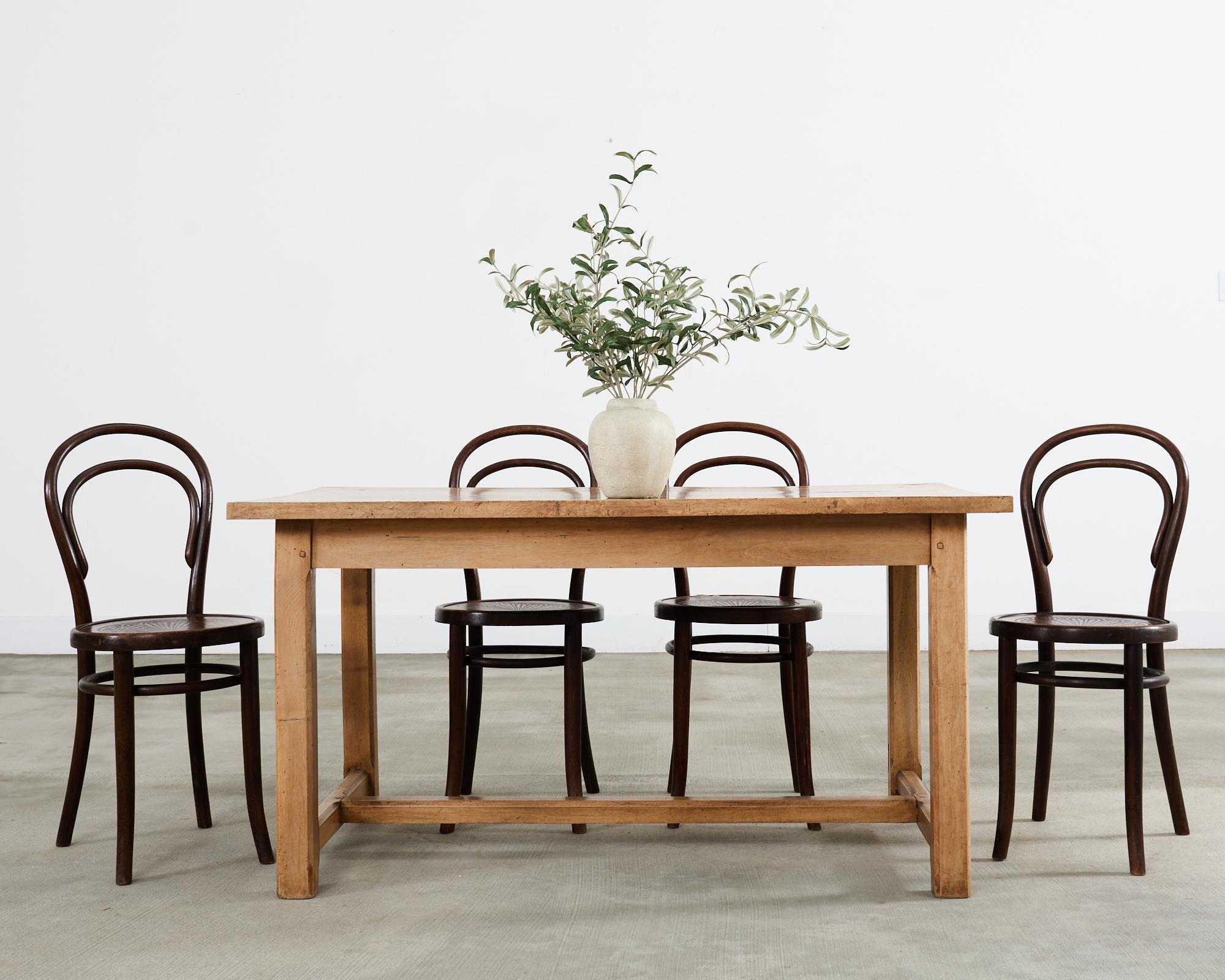 Charmante table de ferme provinciale française du 19e siècle en bois de fruitier. La table se caractérise par un plateau en planches encadré, soutenu par un piètement à tréteaux. Le bois fruitier présente une patine vieillie, vieillie, délavée, aux
