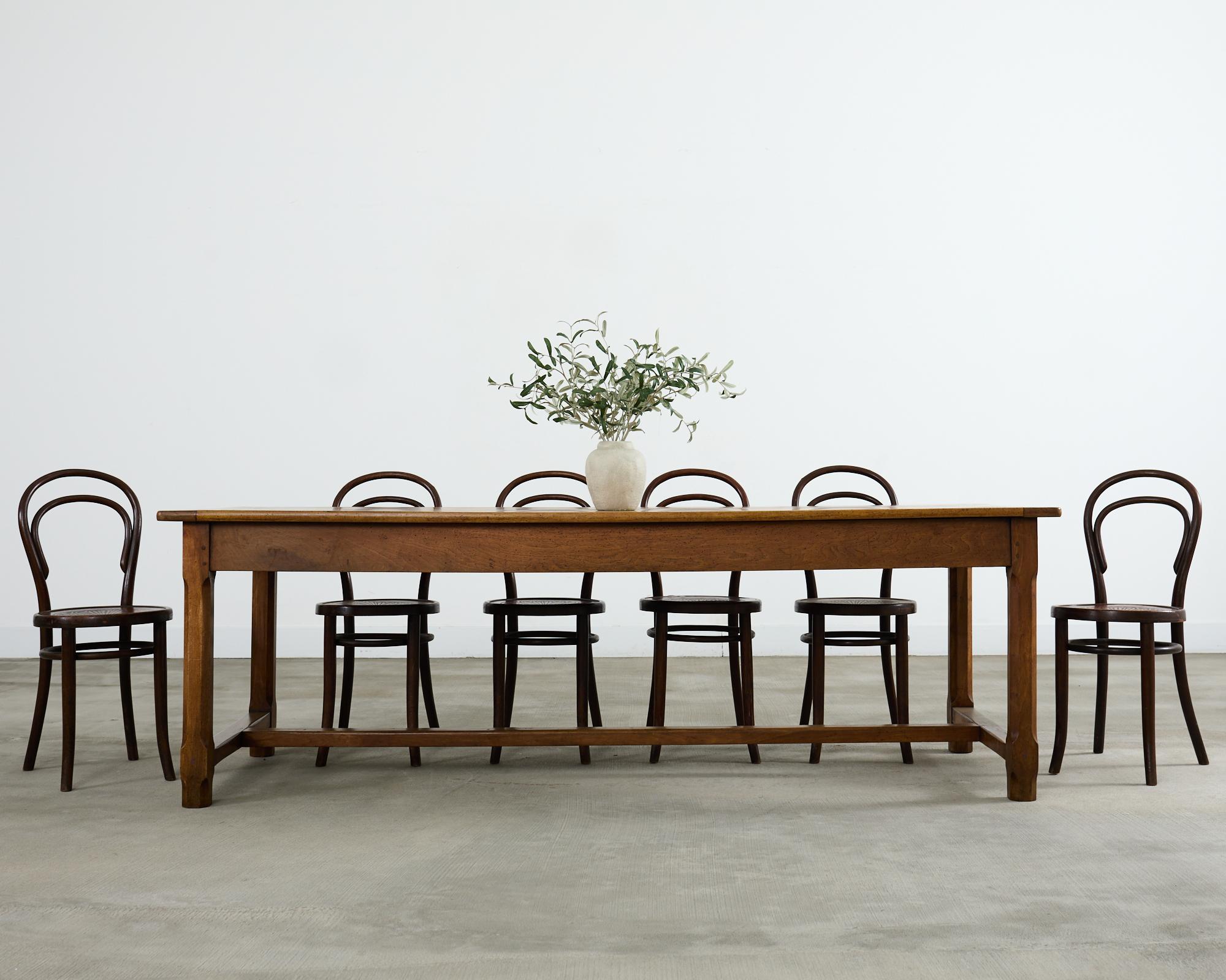 Quintaesencia de la mesa de comedor de granja francesa del siglo XIX o mesa de cosecha, fabricada en madera de frutal. La mesa tiene un tablero largo de 2,5 cm de grosor con extremos de tablero de pan. La parte superior se apoya en un largo