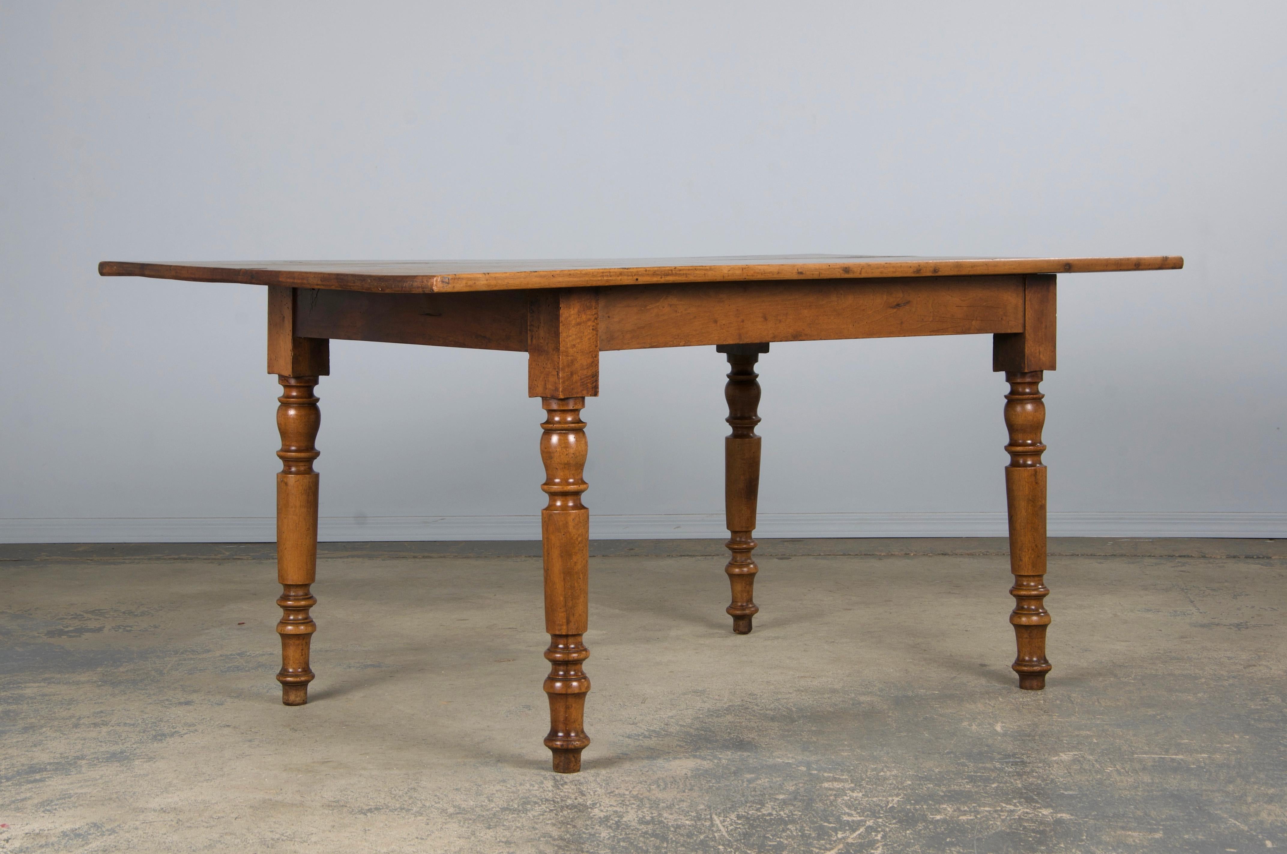 Une table rustique de ferme française du XIXe siècle, provenant de Provence, France. Fabriqué à la main en noyer massif, il présente un plateau rectangulaire de 4,85 pieds de long en noyer magnifiquement vieilli, plein de caractère naturel et d'une