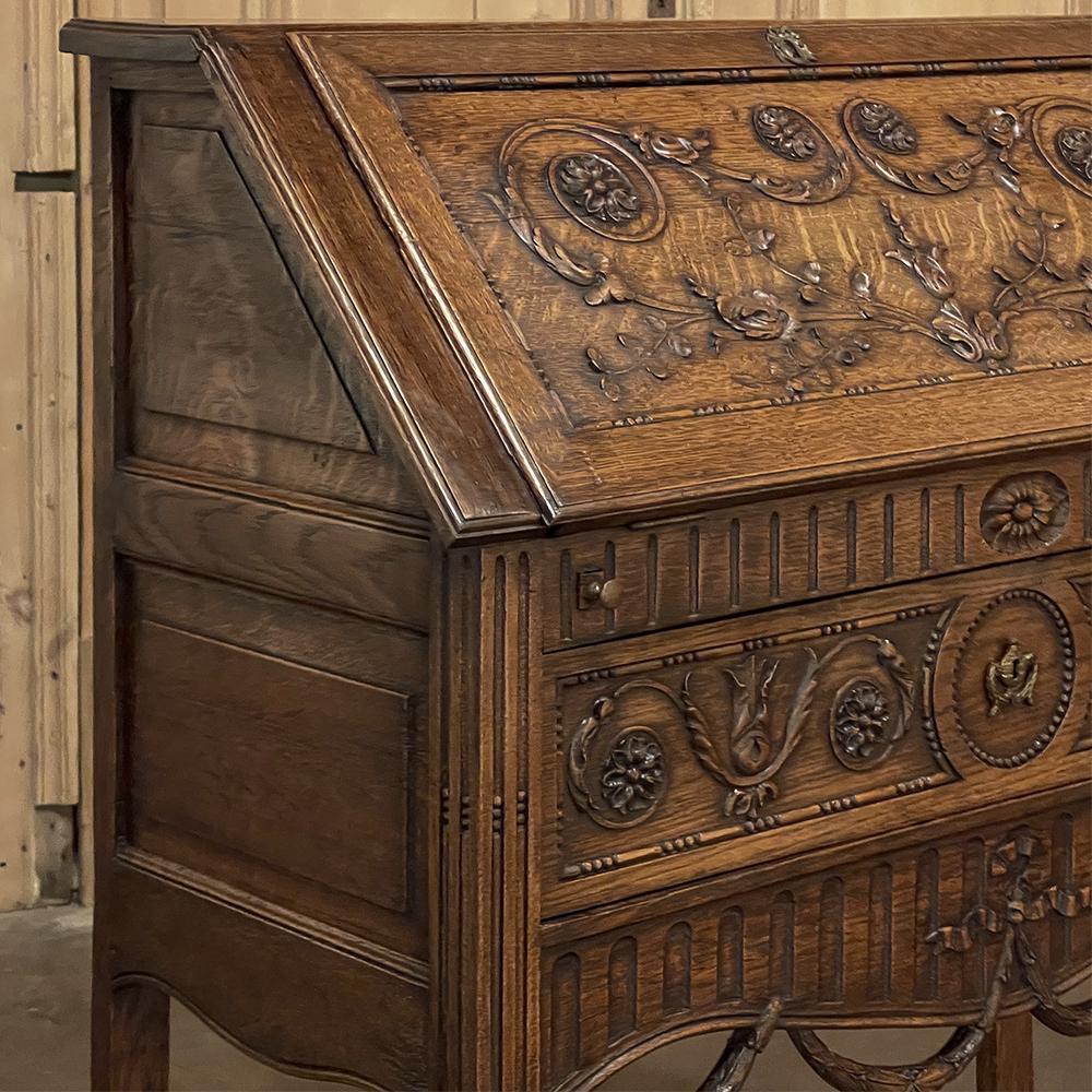 19th Century Country French Louis XVI secretary is a truly astonishing work of the cabinetmaker's art! Hand-crafted from solid old-growth indigenous oak, it features a slim profile that extends out from the wall only sixteen inches, yet with the