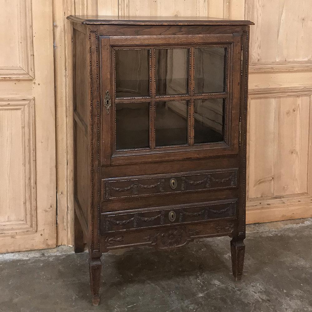 19th century charming Country French Louis XVI Vitrine, chiffonier was hand-crafted in the provinces by talented rural artisans in the neoclassic style so adored by Louis XVI and Marie Antoinette. Utilizing indigenous old-growth oak, the artisans