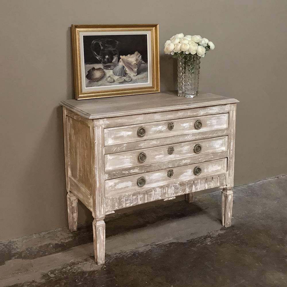 19th century country French Louis XVI whitewashed pine commode is a diminutive and rustic expression of the genre, with naught but simple fluting as the only wood adornment! In stark contrast, it sports exquisite jewelry-quality cast bronze drawer