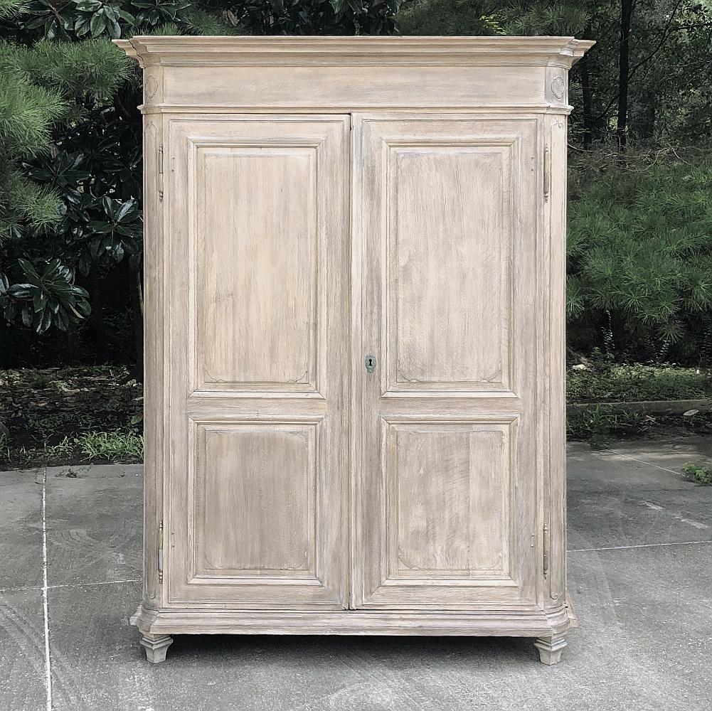 19th Century country French neoclassical whitewashed armoire is a majestic example of the revival of architecture that dates back to ancient Greece and Rome! The tailored design is enhanced by mitered corner posts that are also rounded, and the