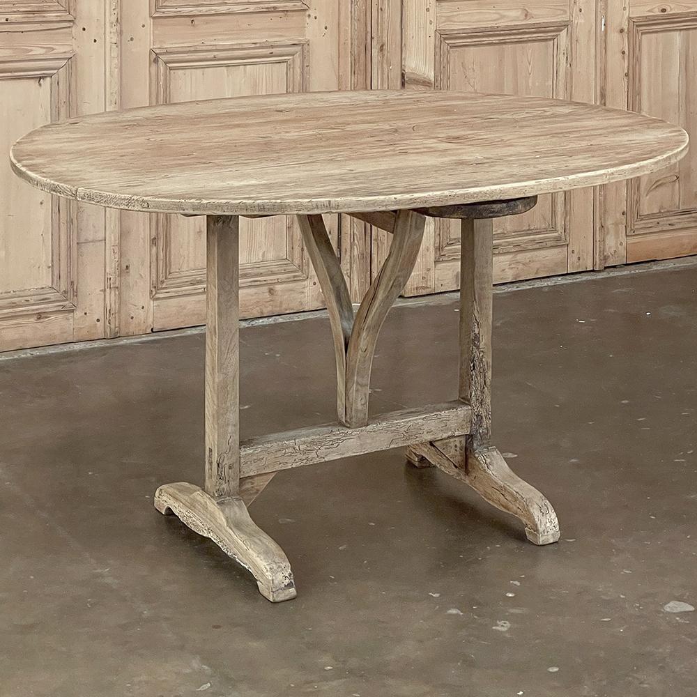 19th century Country French Oval Tilt-Top Wine Tasting Table in Stripped Pine is a charming relic from a bygone era, when vintners stored wine in barrels in the cellar, and from time to time needed to sample the barrels to gauge the progress of the