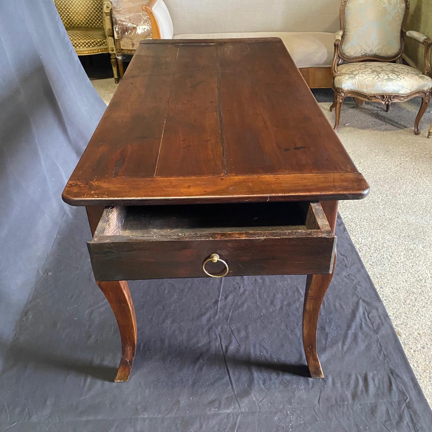 Table de salle à manger provinciale en cerisier français de qualité supérieure avec plateau rectangulaire et extrémités en planches à pain.  Joli et élégant tablier sculpté, reposant sur 4 pieds cabriole avec des pieds sculptés. Petites marques de