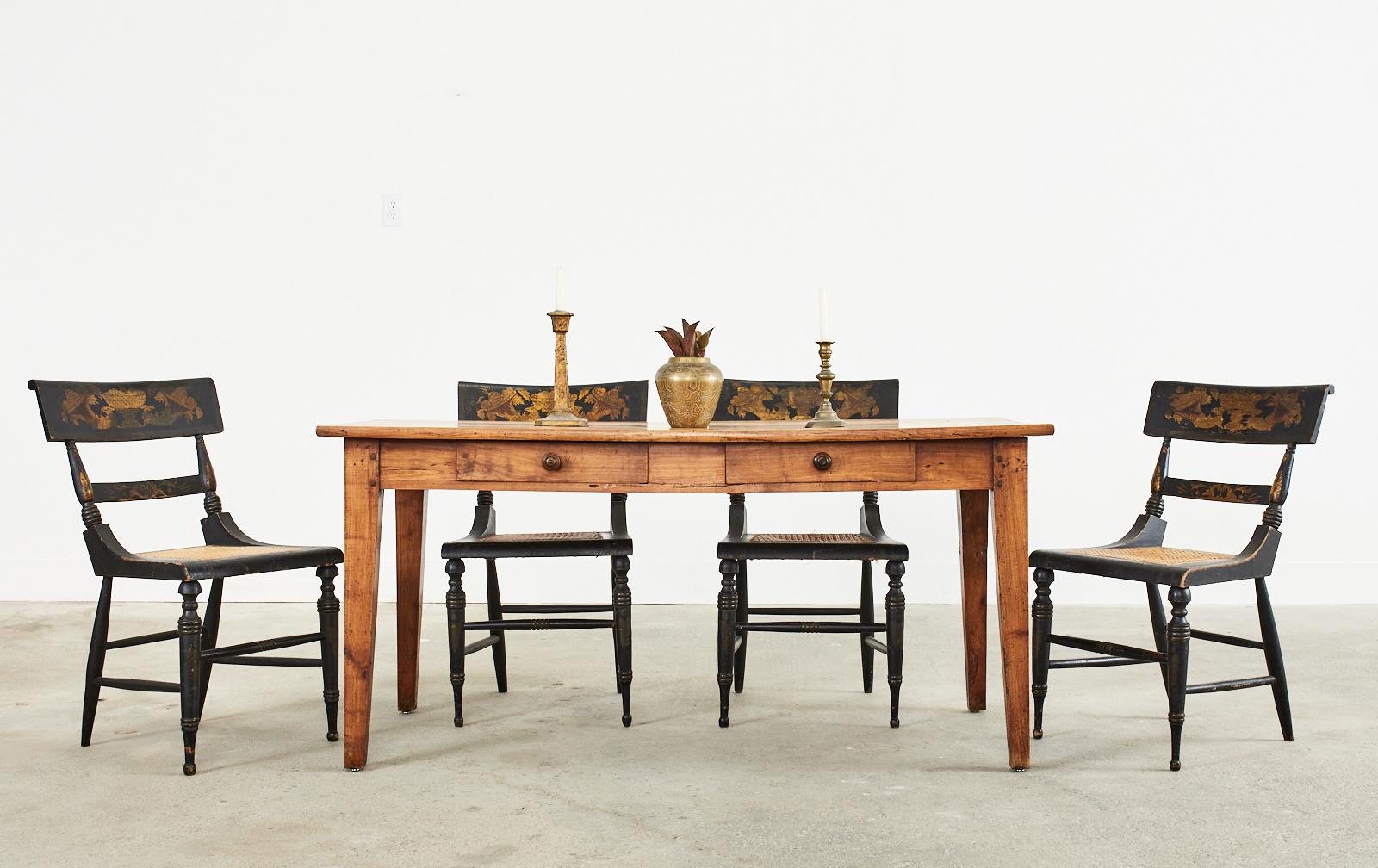 Rustic 19th century country french Provincial farmhouse dining or harvest table constructed from fruitwood. The table features a plank top with 1 inch thick boards. The frieze has two storage drawers and is supported by 3 inch thick square legs that