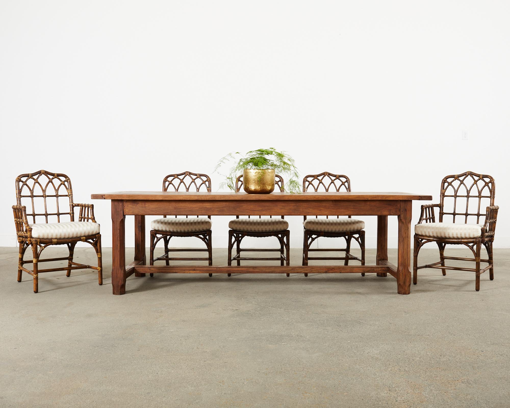 Classic country French provincial 19th century farmhouse dining table or harvest table crafted from fruitwood. The table features a massive 1.5 inch thick plank top over 8 feet long with bread board ends. The top is supported by a trestle base with