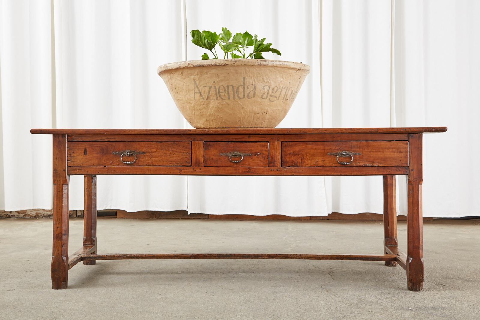 Rustic 19th century country French provincial farmhouse work table or console table. Constructed from fruitwood that appears to be cherry with wood peg joinery. The top is crafted from 1 inch thick planks. The frieze has three large storage drawers