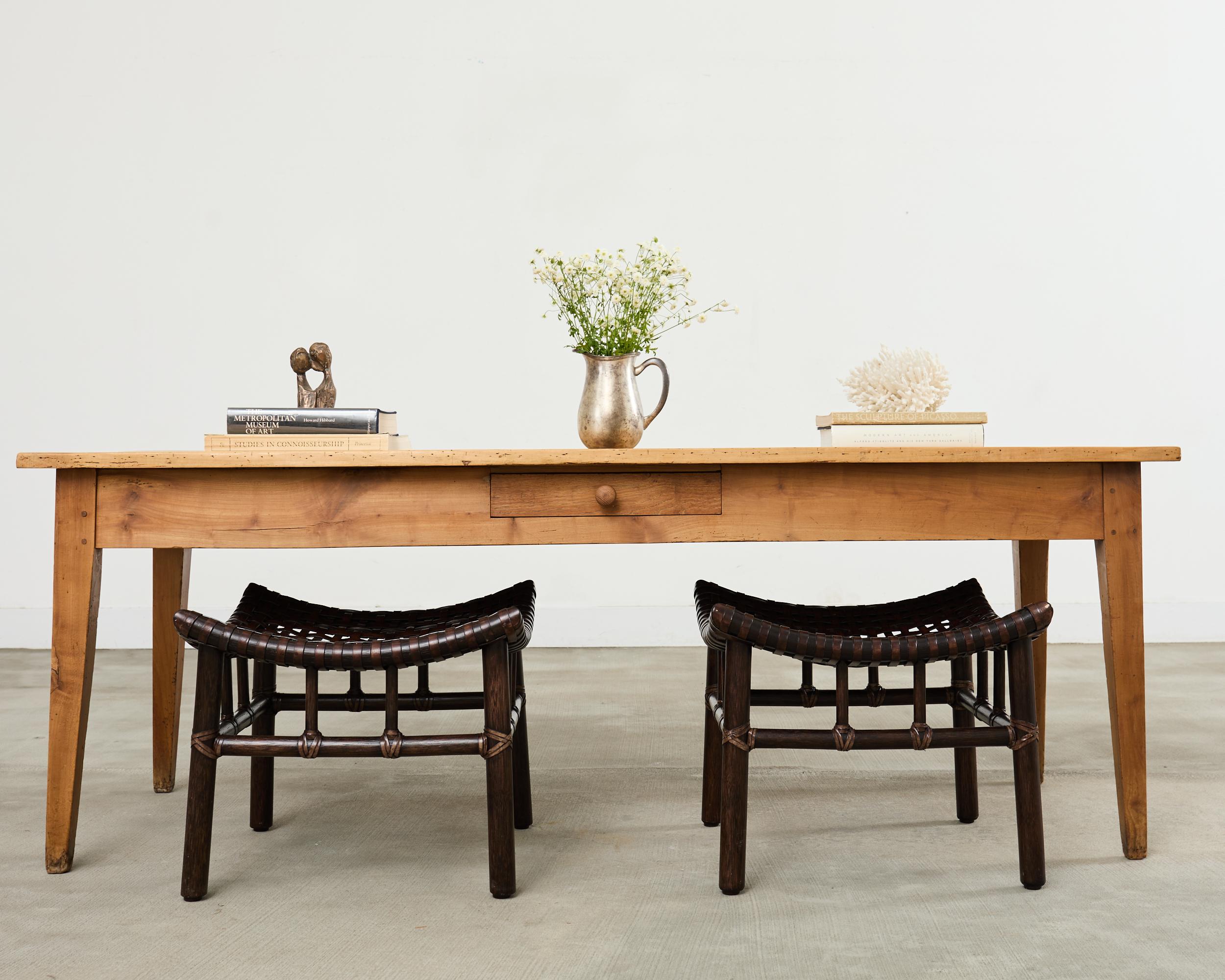 Charmante table de travail de ferme provinciale française de la fin du 19e siècle, fabriquée en bois fruitier. La table est dotée d'un plateau en planches de 1 pouce d'épaisseur et d'un petit tiroir de rangement dans la frise d'un côté. La table est