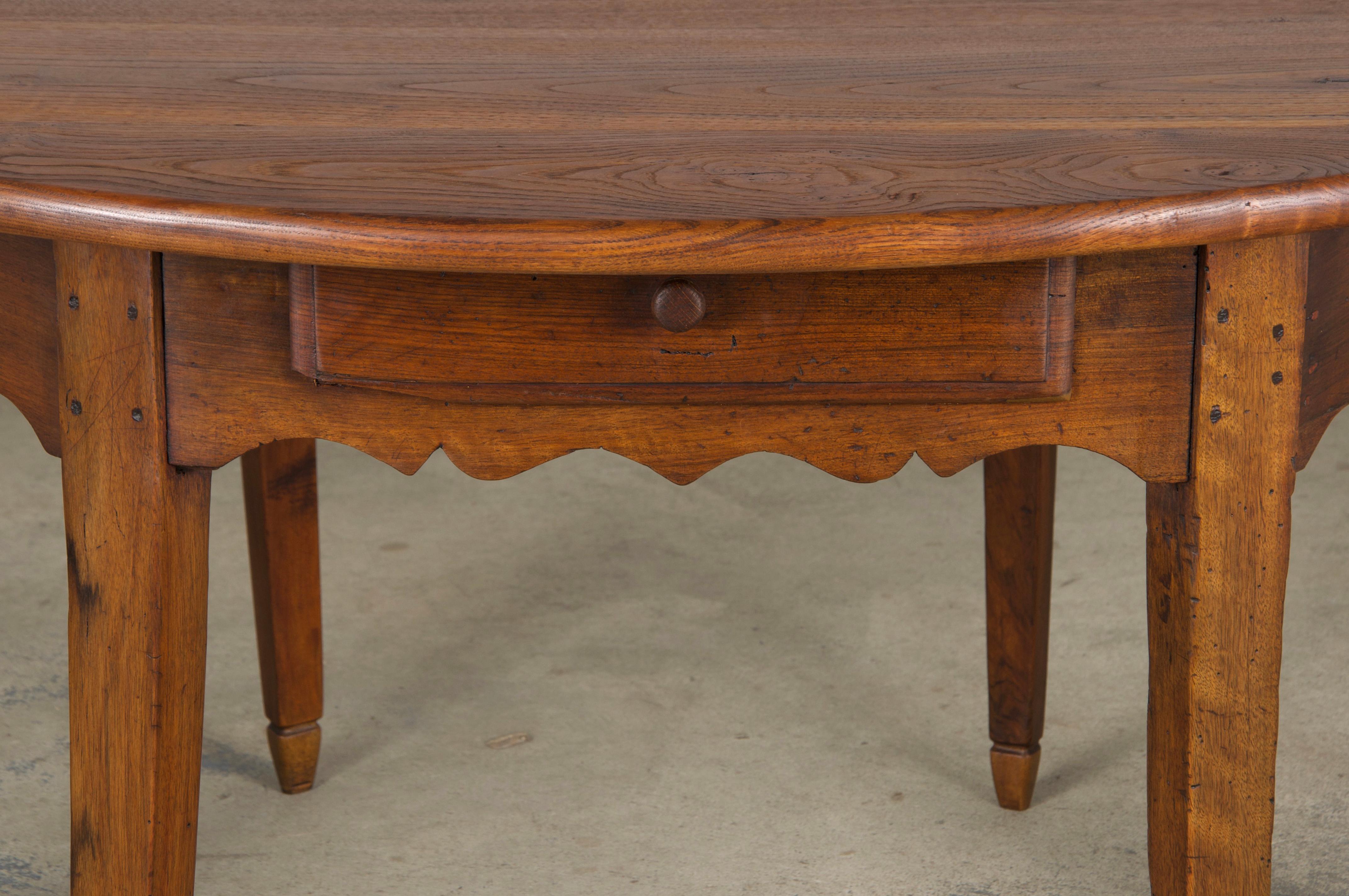 Charmante table de cuisine ou grande console rustique de style provincial français du début du XIXe siècle, provenant de Provence, France. Magnifiquement fabriqué à la main en bois fruitier massif, il présente un plateau décentré et a fait l'objet