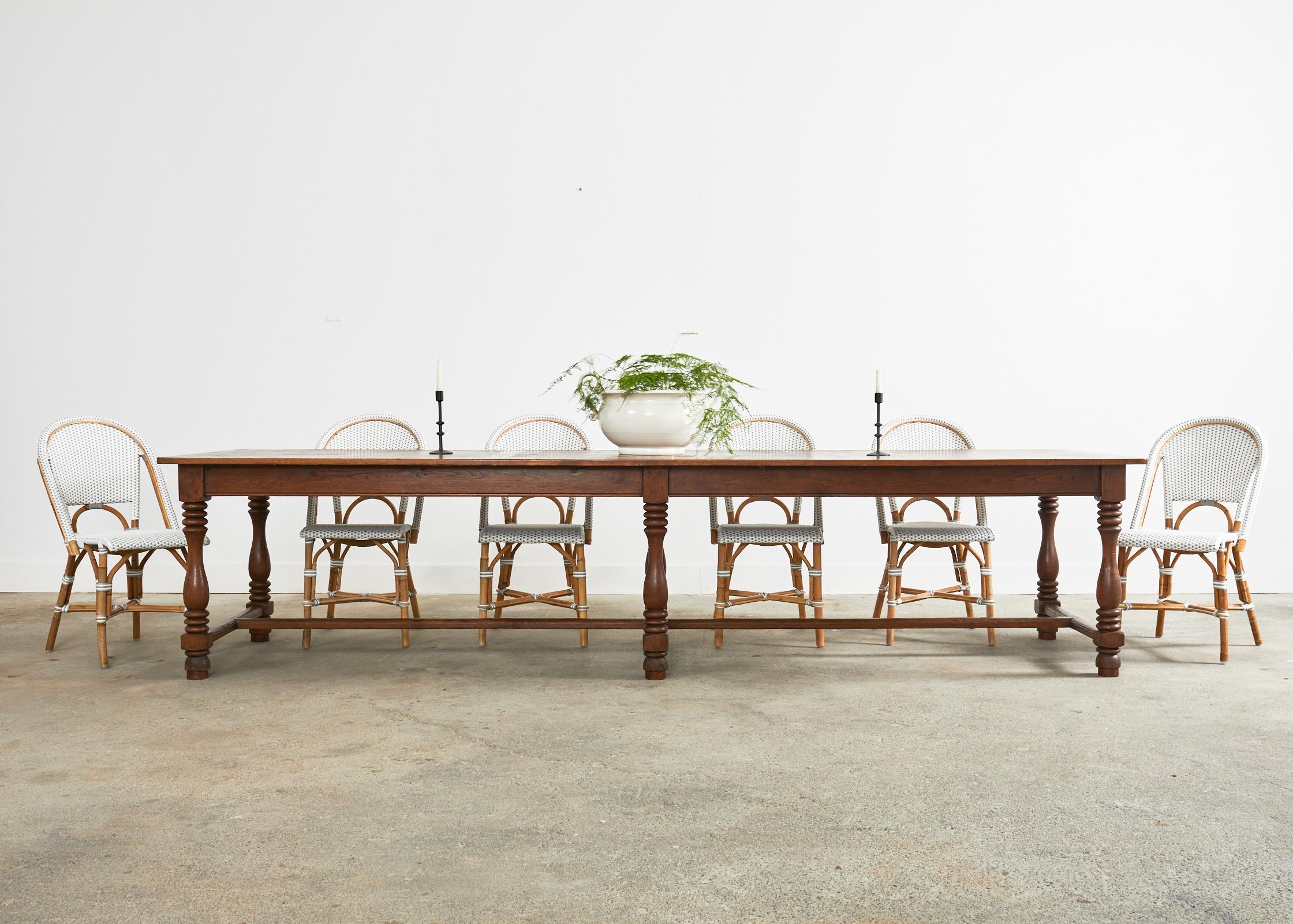 Grand 19th century country French provincial farmhouse dining table, harvest table, or refectory table crafted from oak. The monumental table features a six leg trestle style base with wood peg construction. Ample leg room measuring 24.5 inches from