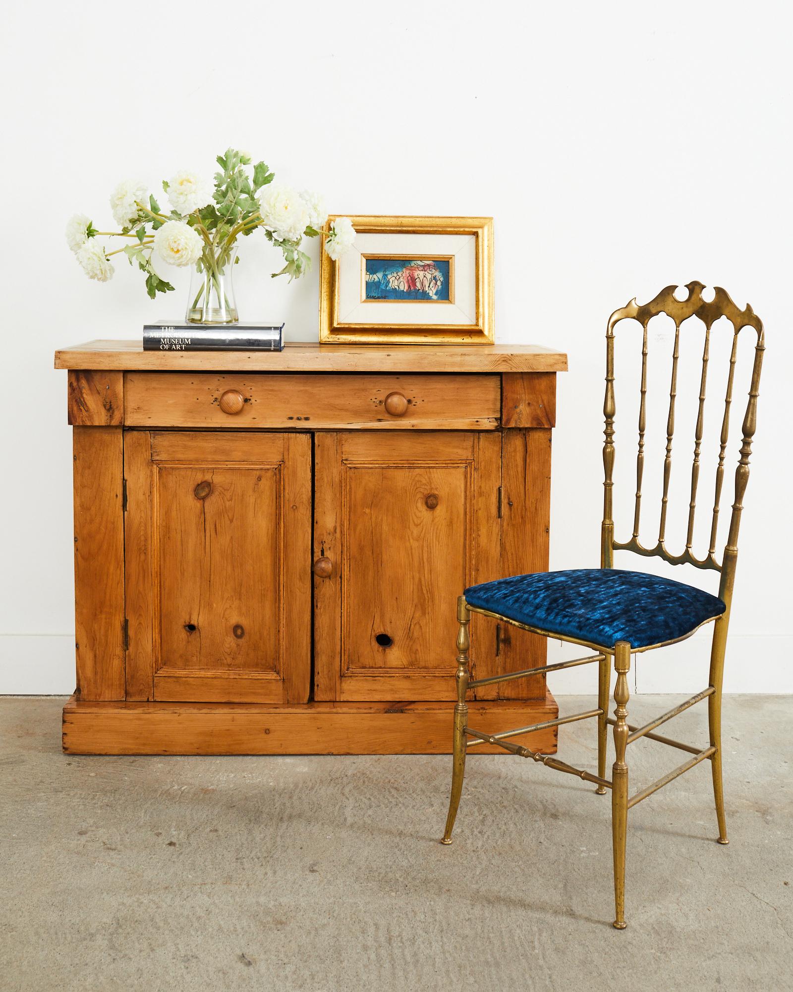 Rustic 19th century country French provincial farmhouse sideboard cabinet or server. Crafted from pine and fruitwood with a lovely warm honey tone and rich woodgrain patterns. Very light cabinet constructed from thin planks of wood. The front has a