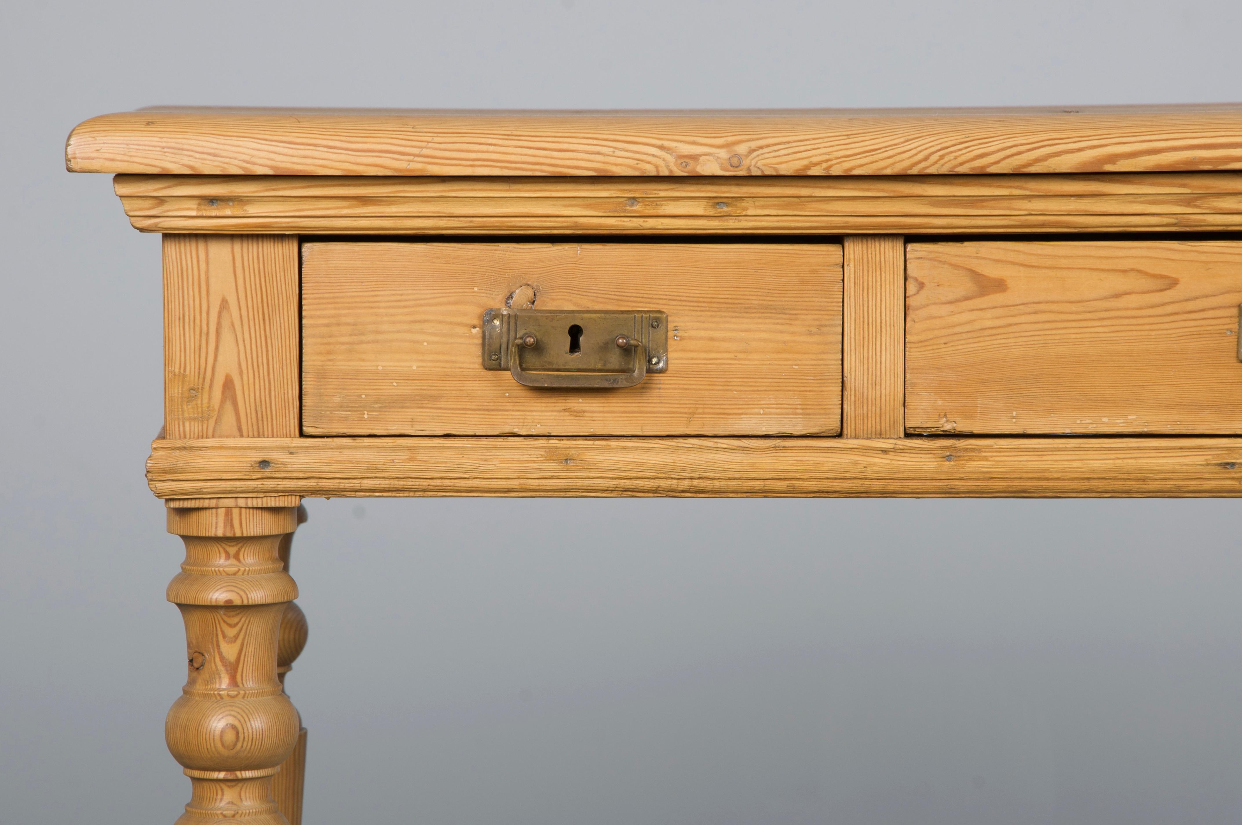 A charming late 19th-century French Provincial writing desk, side table, or console, sourced from Provence, France. Beautifully handcrafted from solid rustic European pine, it features a naturally aged patina in a warm soft tan hue, finished with