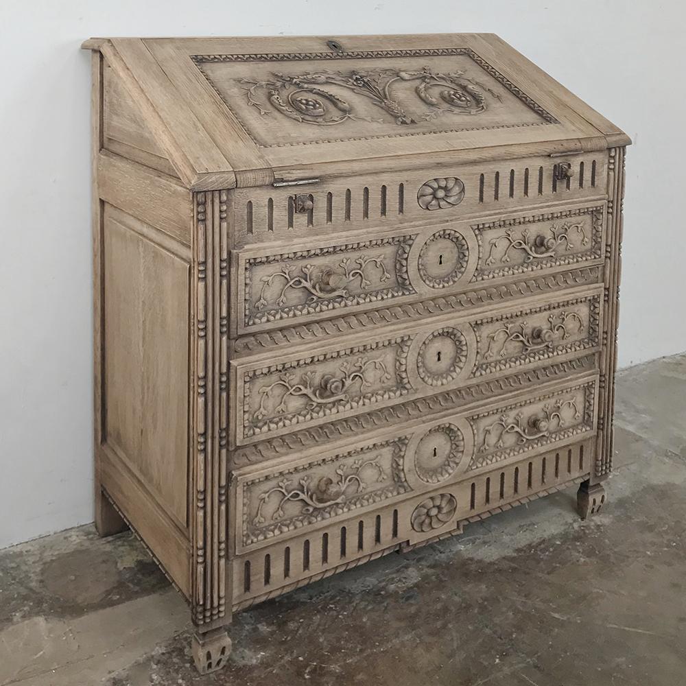 19th century Country French provincial stripped oak secretary is a delightfully hand carved expression of rural artisanry that also represents an exceptional workstation and storage in the chest pf drawers that will add as much panache to your decor