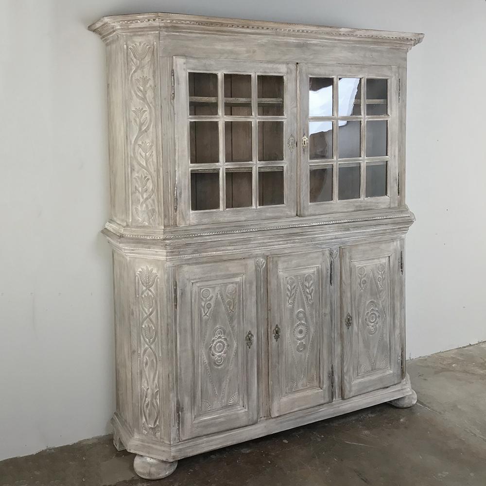 19th century Country French rustic whitewashed bookcase, cabinet can store and display copious amounts of books, keepsakes, and family heirooms! Mitered corners eases the effect of its footprint, with tailored molded detail accentuating the carved
