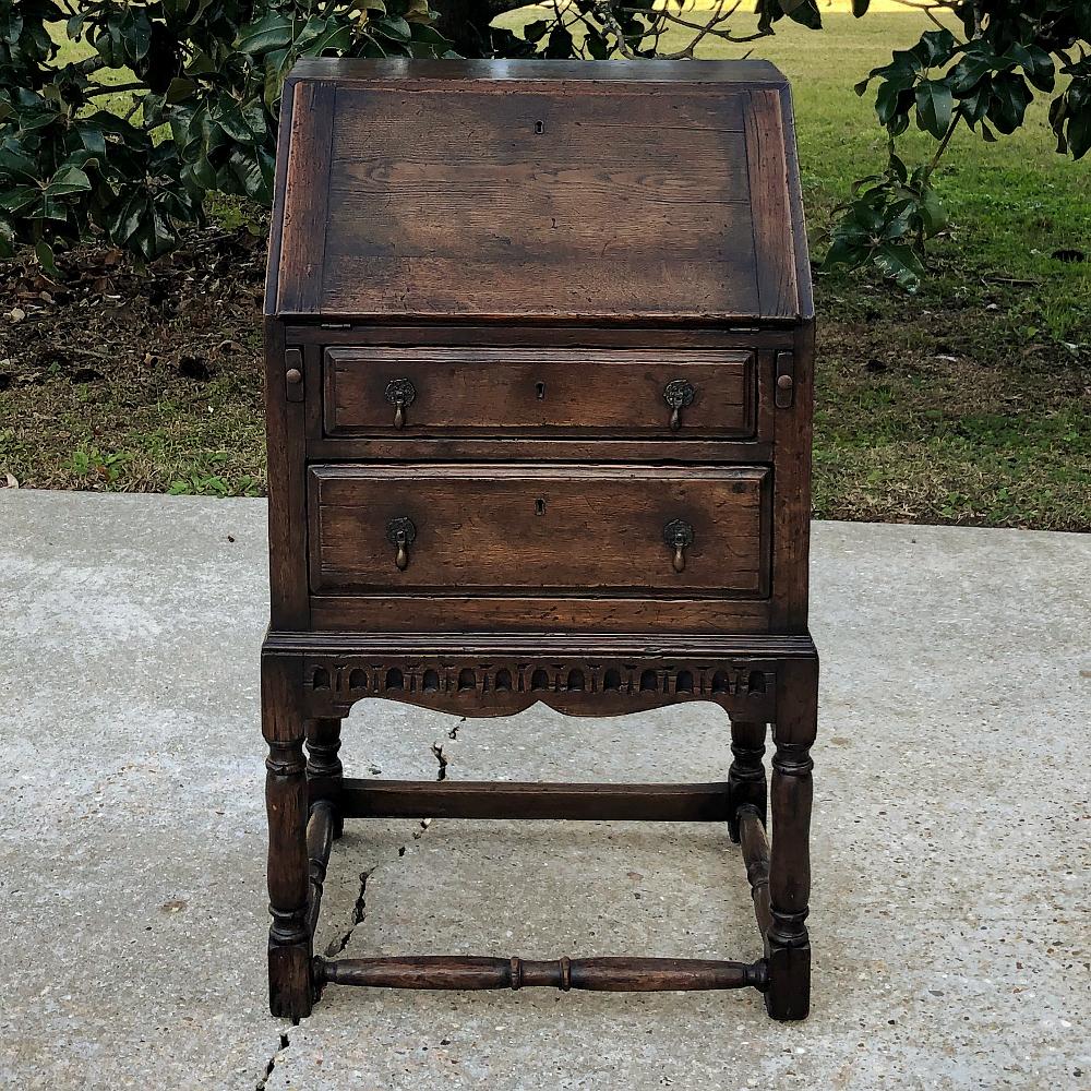 19th century country French secretary was designed with an unusually diminutive width making it the ideal choice for cozy rooms, niches or narrow spaces! Handcrafted from solid old-growth oak, it features a Classic slant front design, with the drop