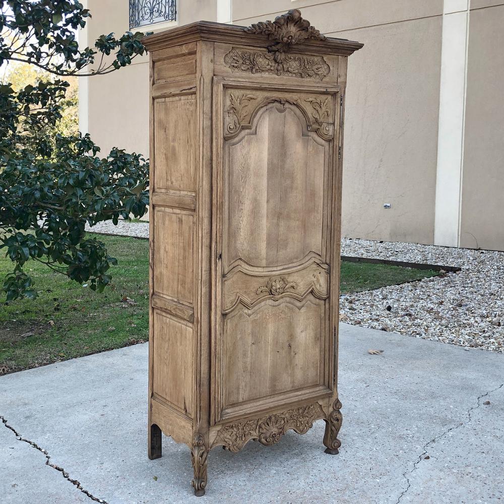 19th century country French stripped oak Bonnetiere represents the epitome of rural craftsmanship, with extraordinary artistry represented in the exquisite sculptural adornment, all rendered from solid indigenous white oak. An elaborate shell motif