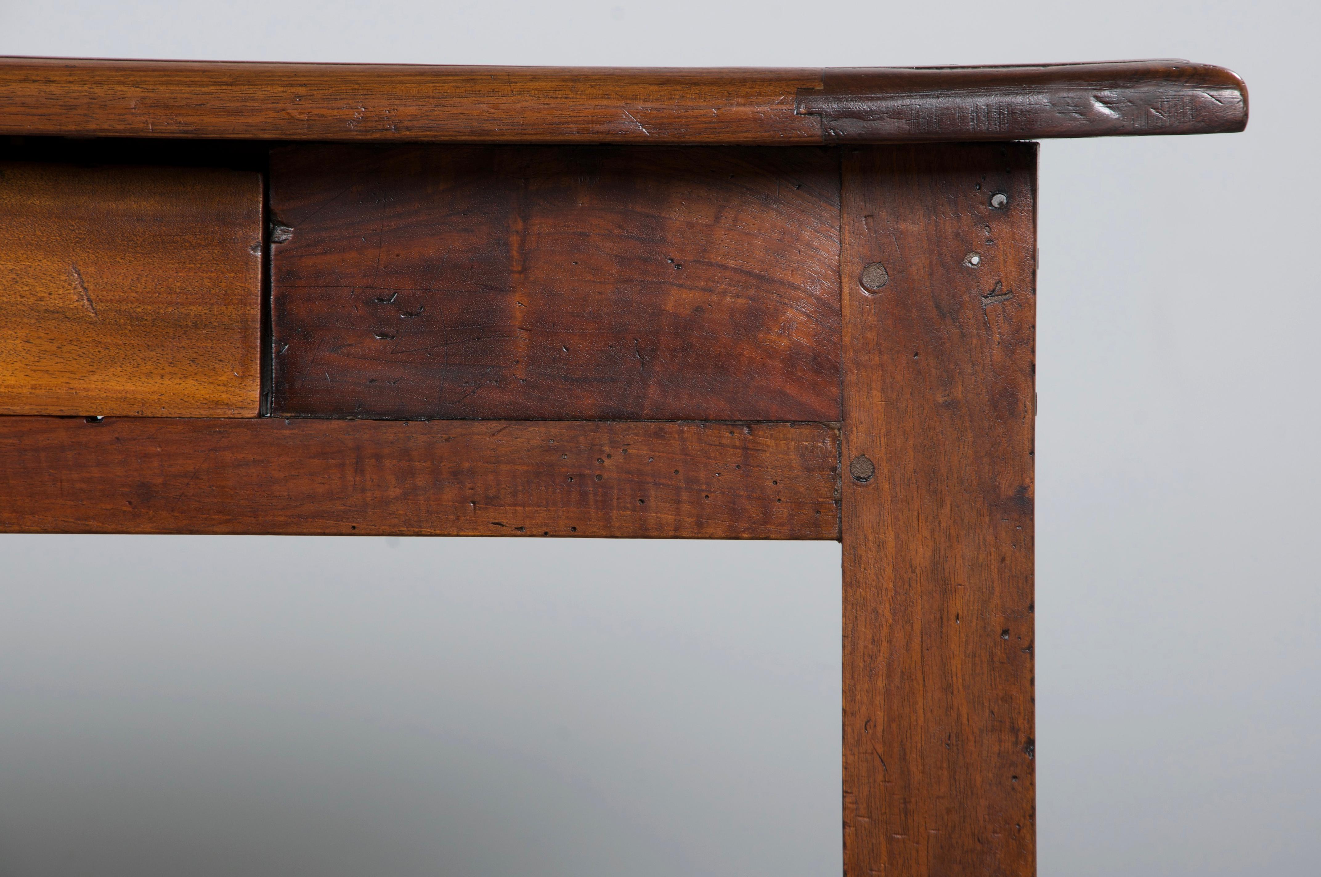 19th-century Country French farmhouse trestle dining table, writing table, or large console, sourced from Provence, France. Expertly hand-crafted from solid walnut, it features a long, narrow rectangular plank top with breadboard ends, joined using