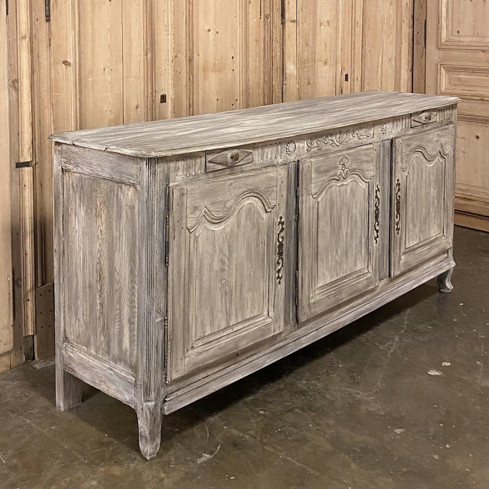19th century country French whitewashed buffet, enfilade features a combination of the charming rural French lines with scrolled frameworks on the cabinet doors, but with Directoire-influenced raised diamonds on the drawers with fluting across the