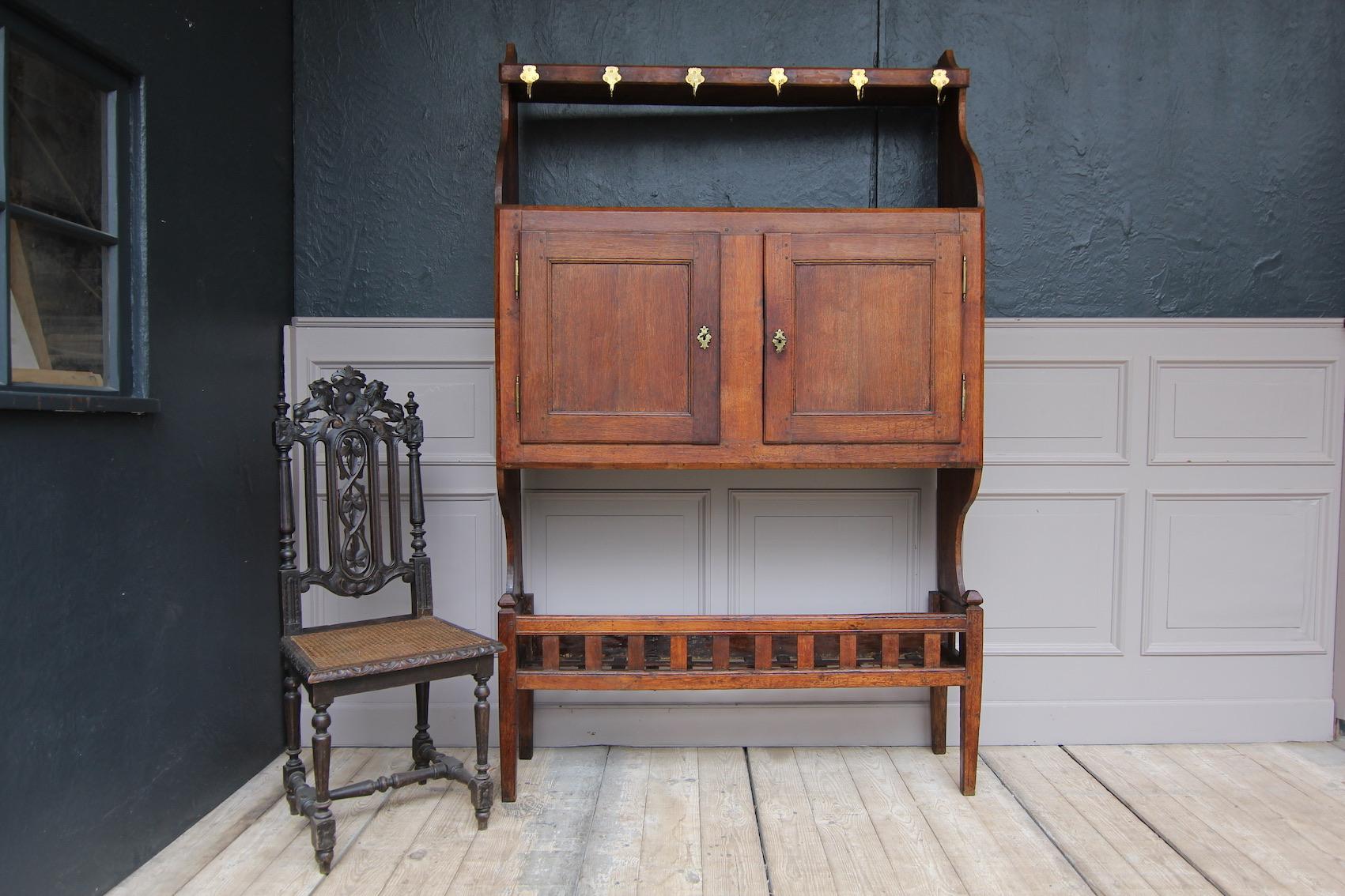 A unique country house pantry cupboard from the 19th century. Made of solid oak.
Later retrofitting or mirroring behind the two doors in the middle part (very heavy as a result).
Shelf with 6 brass hooks.

Dimensions: 
206 cm high / 81.1 inch