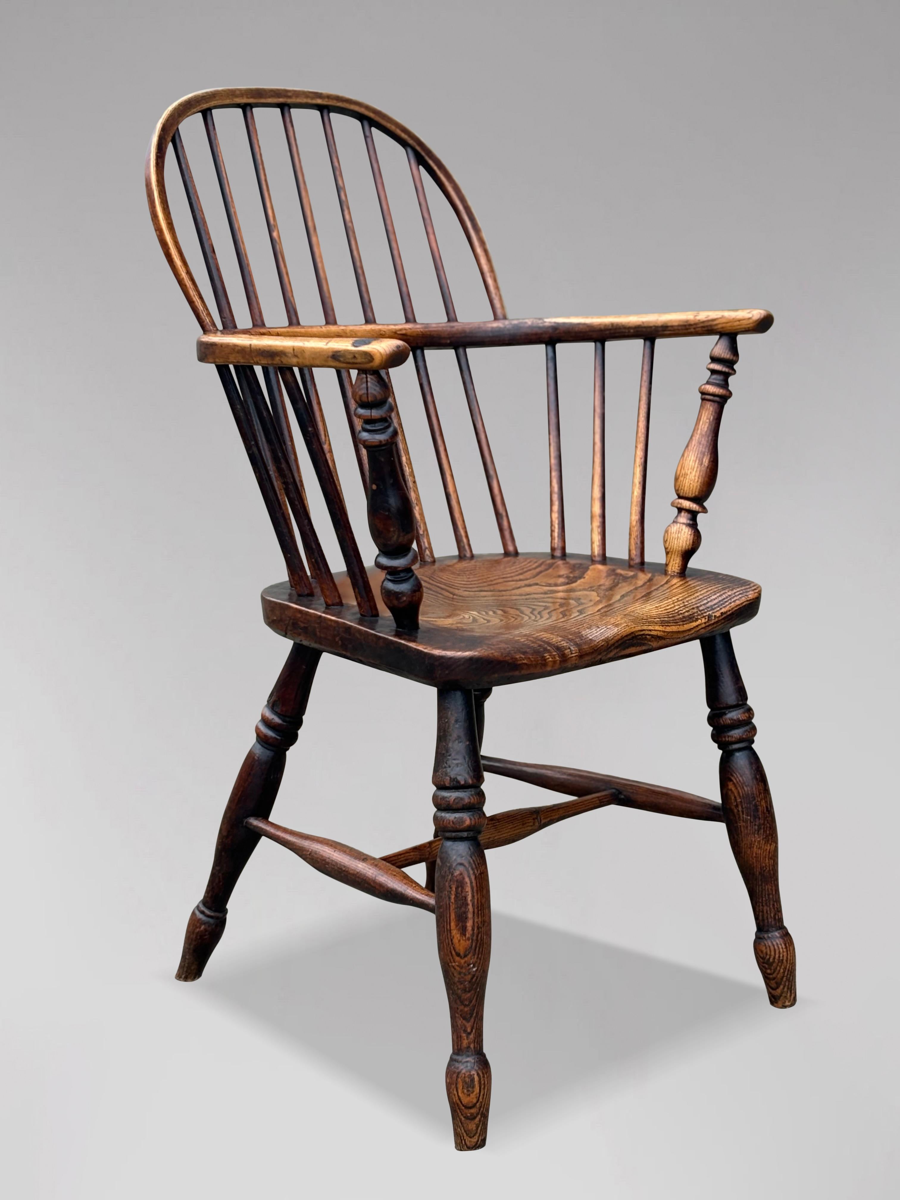 A fine 19th century quality English ash & elm Windsor armchair. Comprising stick and hoop back with a spindle back. The back rail is secured to a stunning solid saddle shaped elm seat with shaped arms on shaped supports. The armchair is raised on