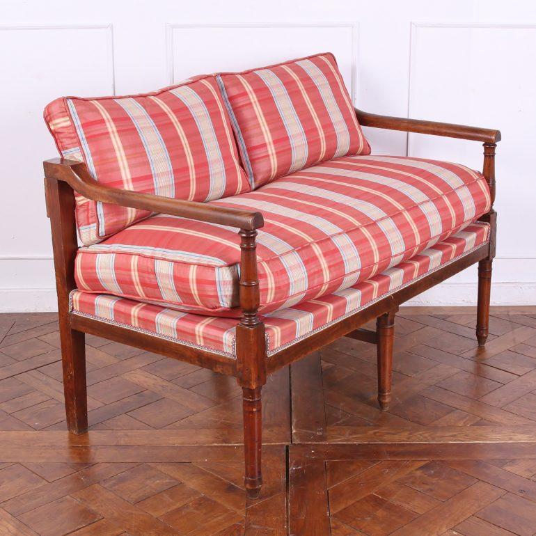 French, 19th century walnut, Empire-style settee with simple turned arms and legs, and recent upholstery.