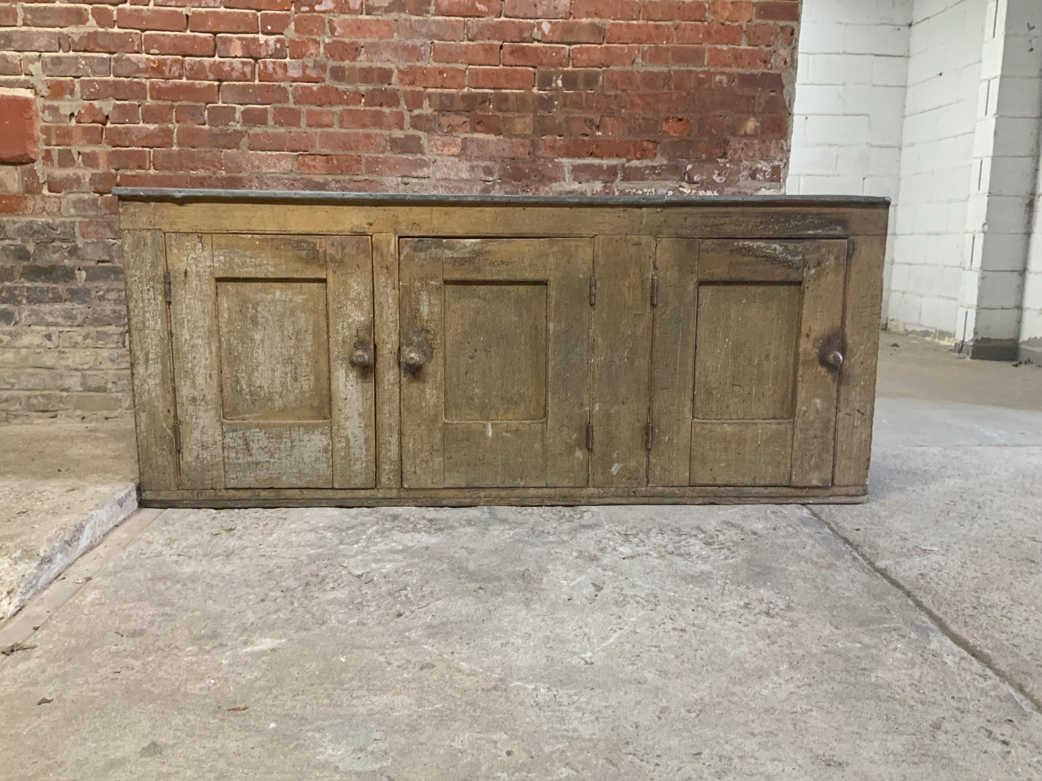 A wonderful piece of 19th century Americana. This painted pine dry sink cabinet has storage on the bottom and a heavy duty zinc top. The wear, surface and patina add to the history and charm of this particular piece. Originally from a Rockland