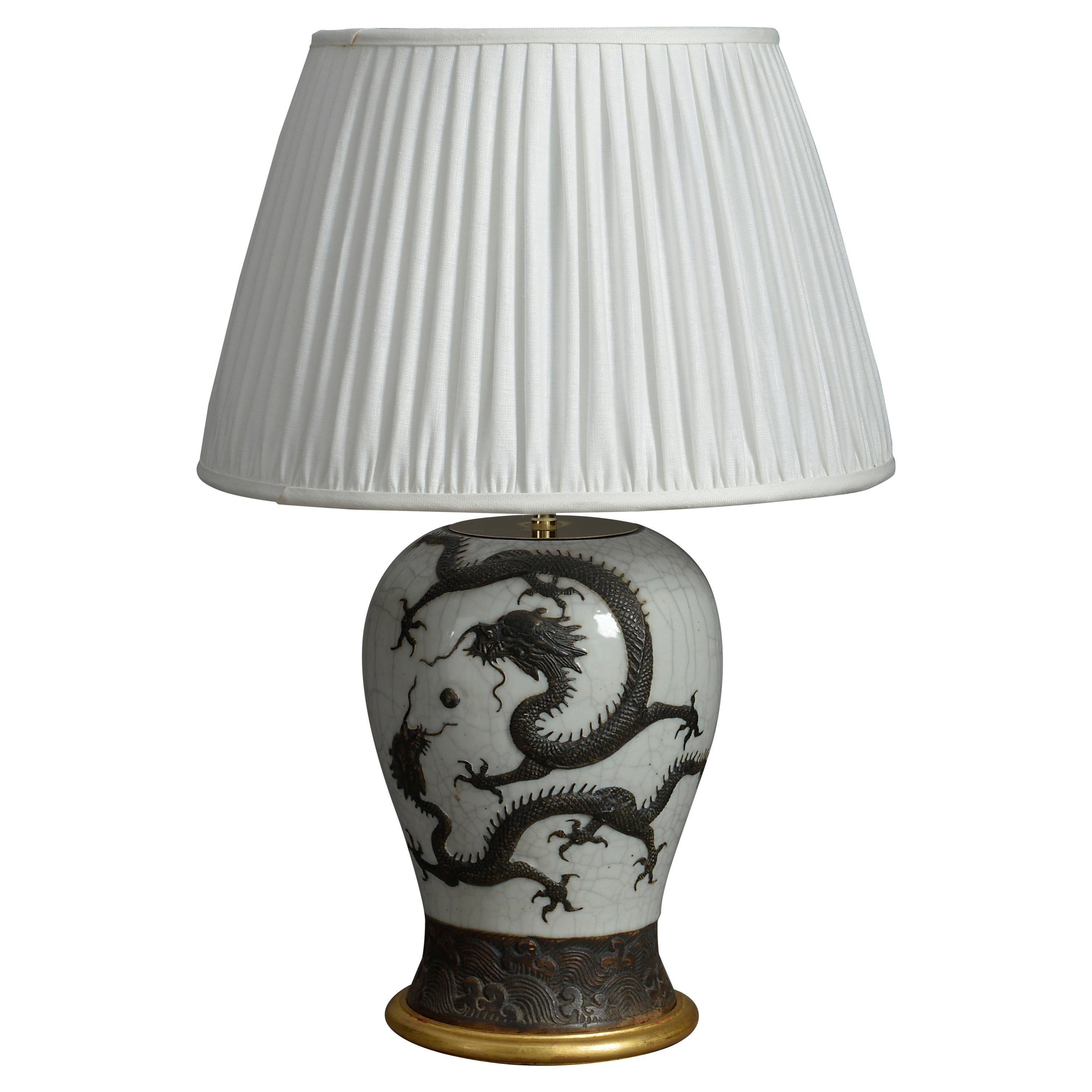 A late 19th century Chinese Export crackle glazed vase, the cream ground with applied bronzed dragon. Set upon a hand-turned giltwood base and mounted as a lamp.

Dimensions refer to porcelain vase and giltwood base only

Shade not included.
