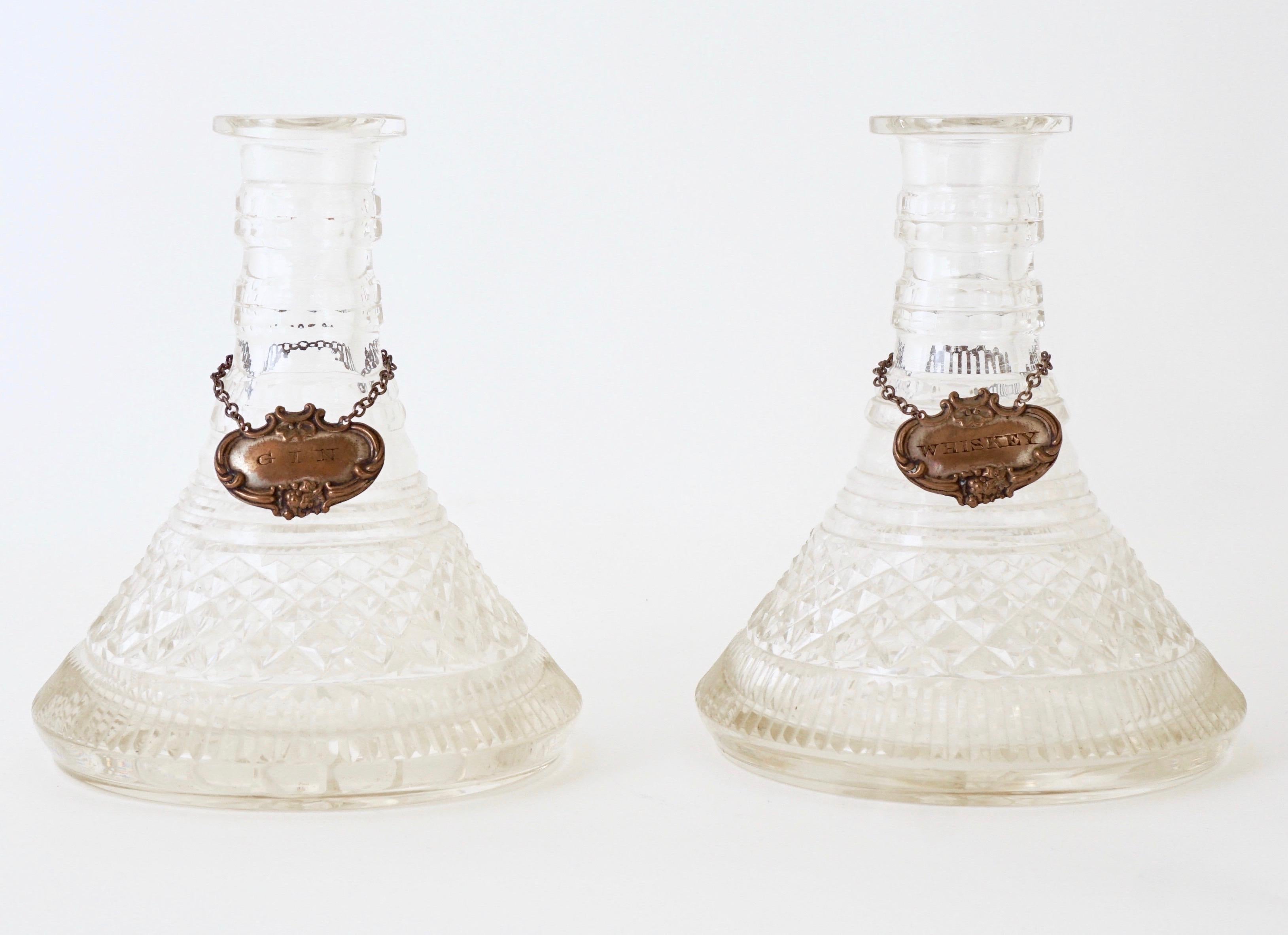 Gorgeous gin and whiskey crystal decanters from the 1800s. These magnificent pair were designed for use on ships. The wide bottoms were to keep them stable when the ship lists. They were likely used in a Captain's stateroom. 
