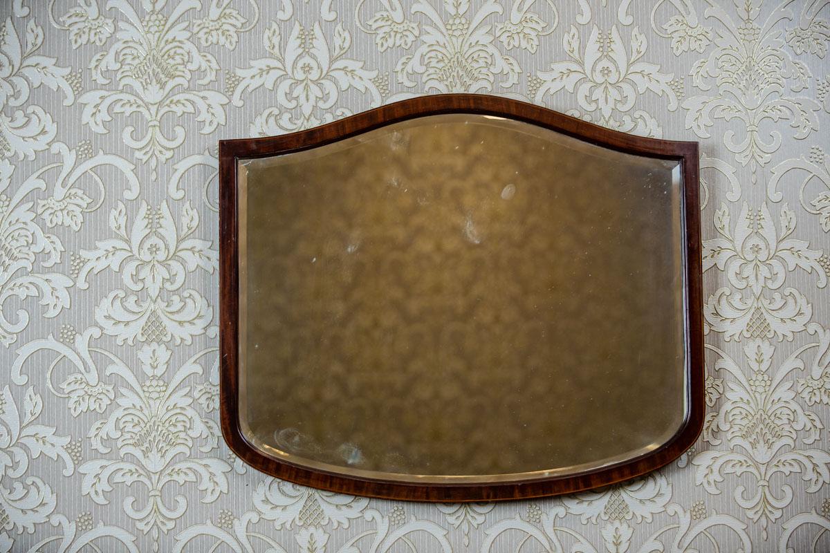 We present you this old, heavy crystal mirror in a smooth wooden frame.
The whole is from the 2nd half of the 19th century.
The simplicity of the frame is only varied by its wavy profile and the decorative graining of the veneer.

The frame is
