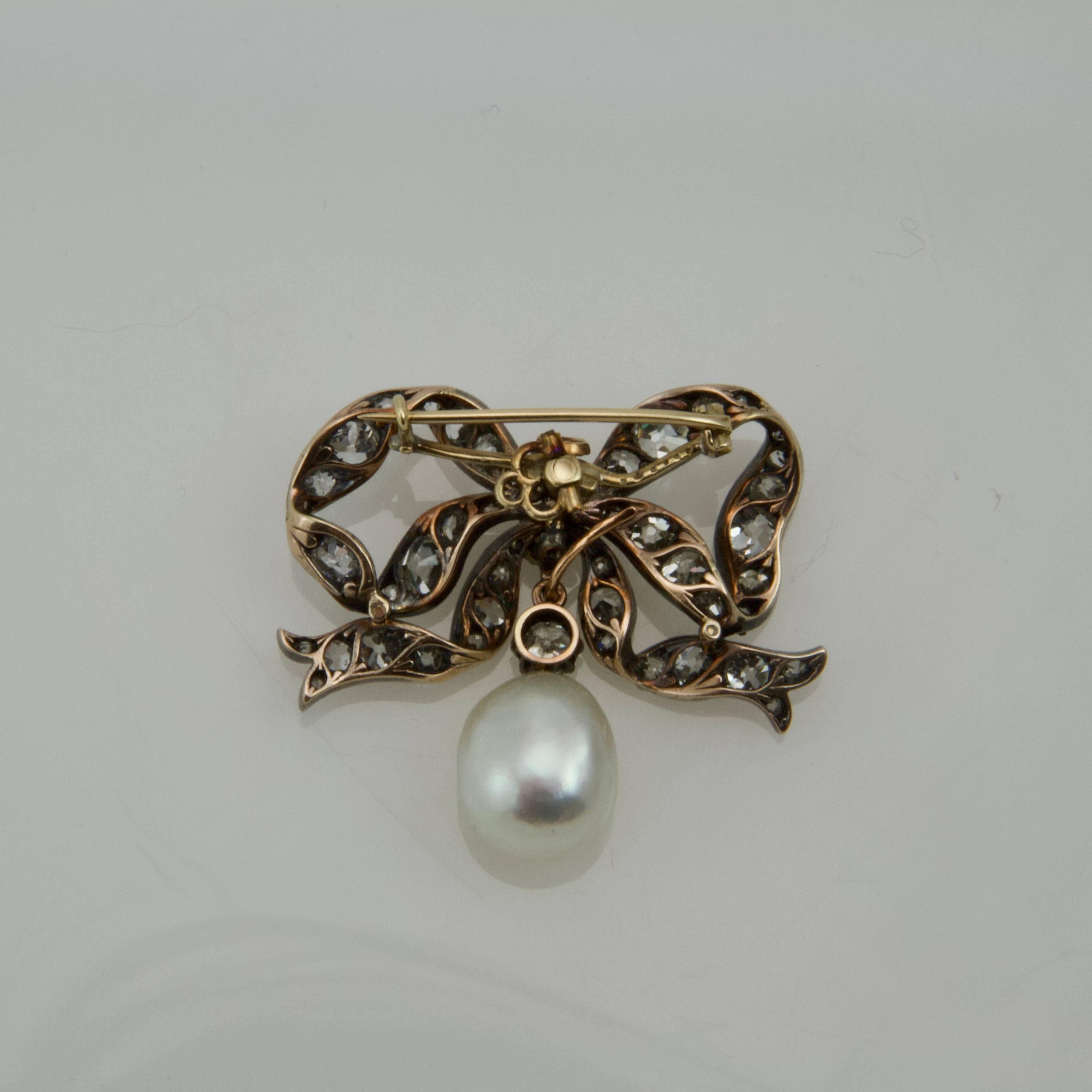 Antique-cut diamond set on gold and silver bow brooch. Removable pear-shaped cultured pearl. 
Possible to wear in pendant ( brooch system removable)
Weight of diamonds almost 5 carats. Quality fair.
Pearl size: 1.2 x 1.5 cm
French recense