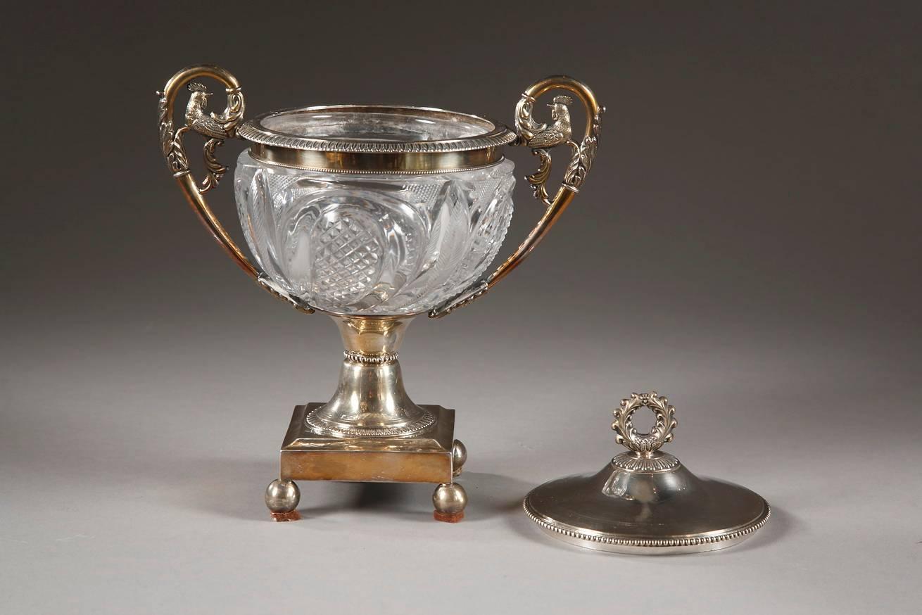 Elegant candy dish in Creusot cut crystal and silver, decorated with foliage and petals. The high handles are embellished with palmettes, acanthus leaves, and the final spiral finishes in the shape of a rooster. A crown-shaped knob adorns the top of