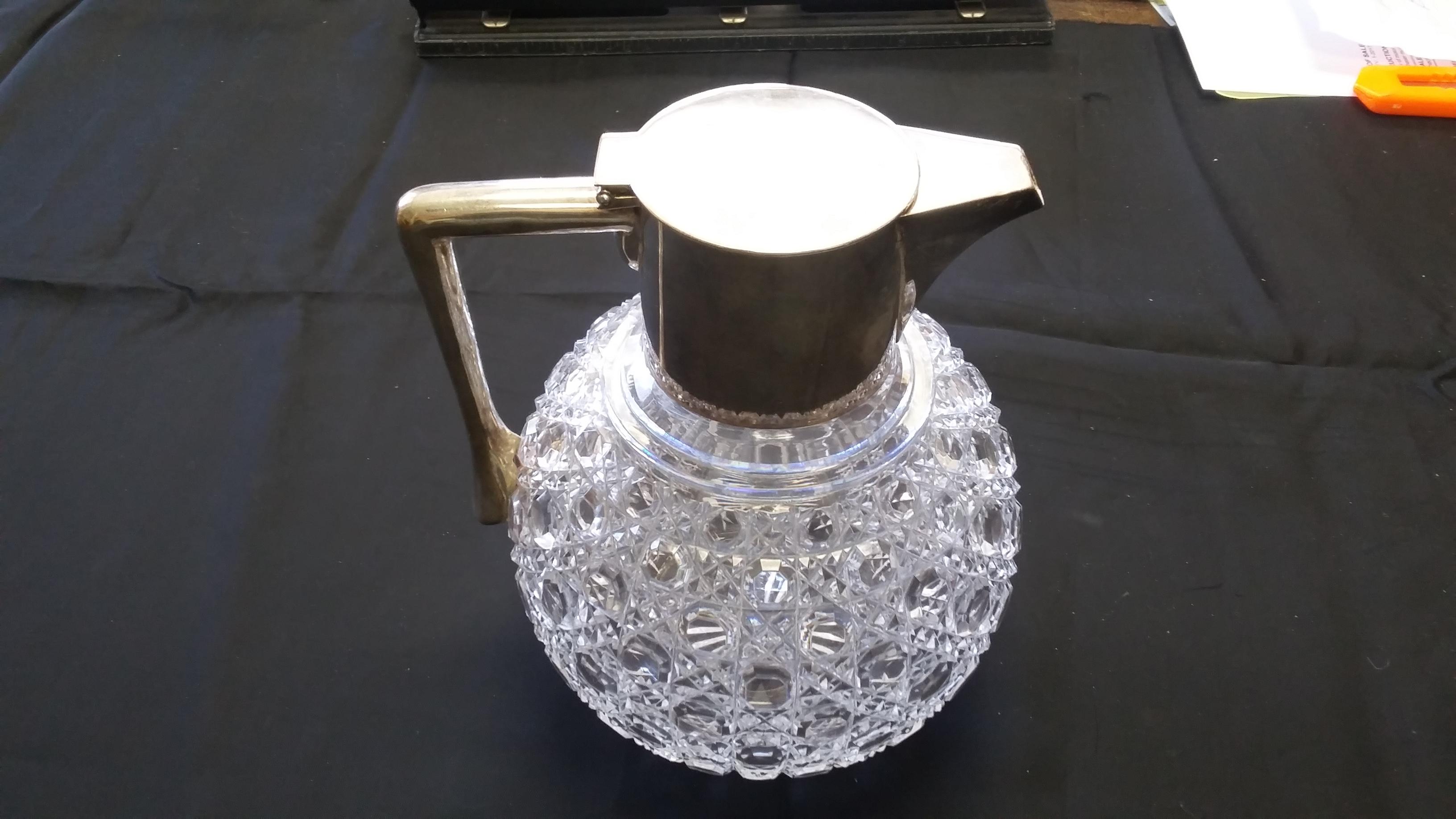 Finely detailed cut glass pitcher with silver plated lid. Markings on the inside of the lid. Starburst cut on the bottom. Hobnail design makes this piece special.