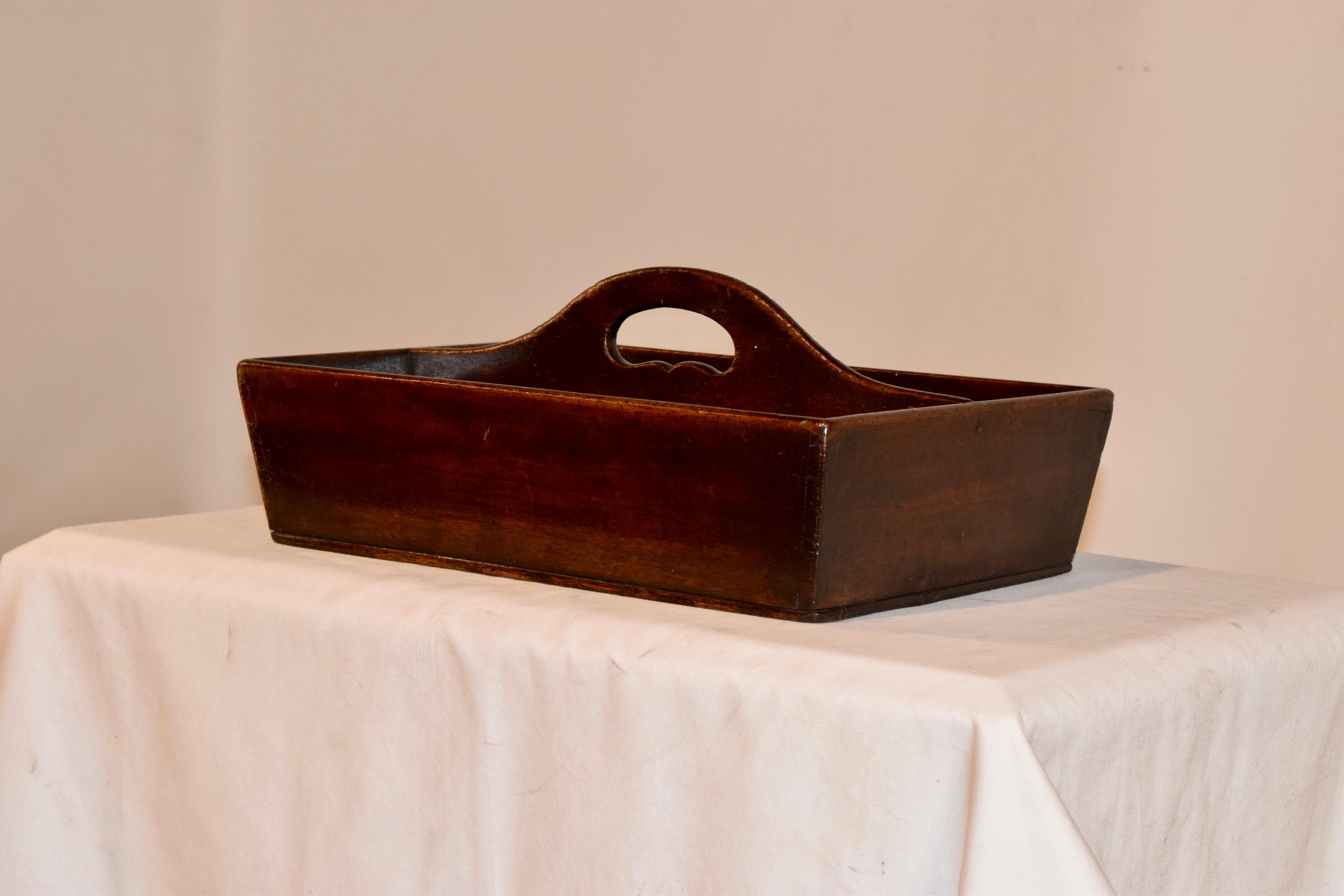 Late 18th century English cutlery caddy made from mahogany. The simplicity of this caddy is elegant and timeless. It has a sloping handle with a cutout for carrying and splayed sides, all made from wonderfully grained mahogany with a rich patina