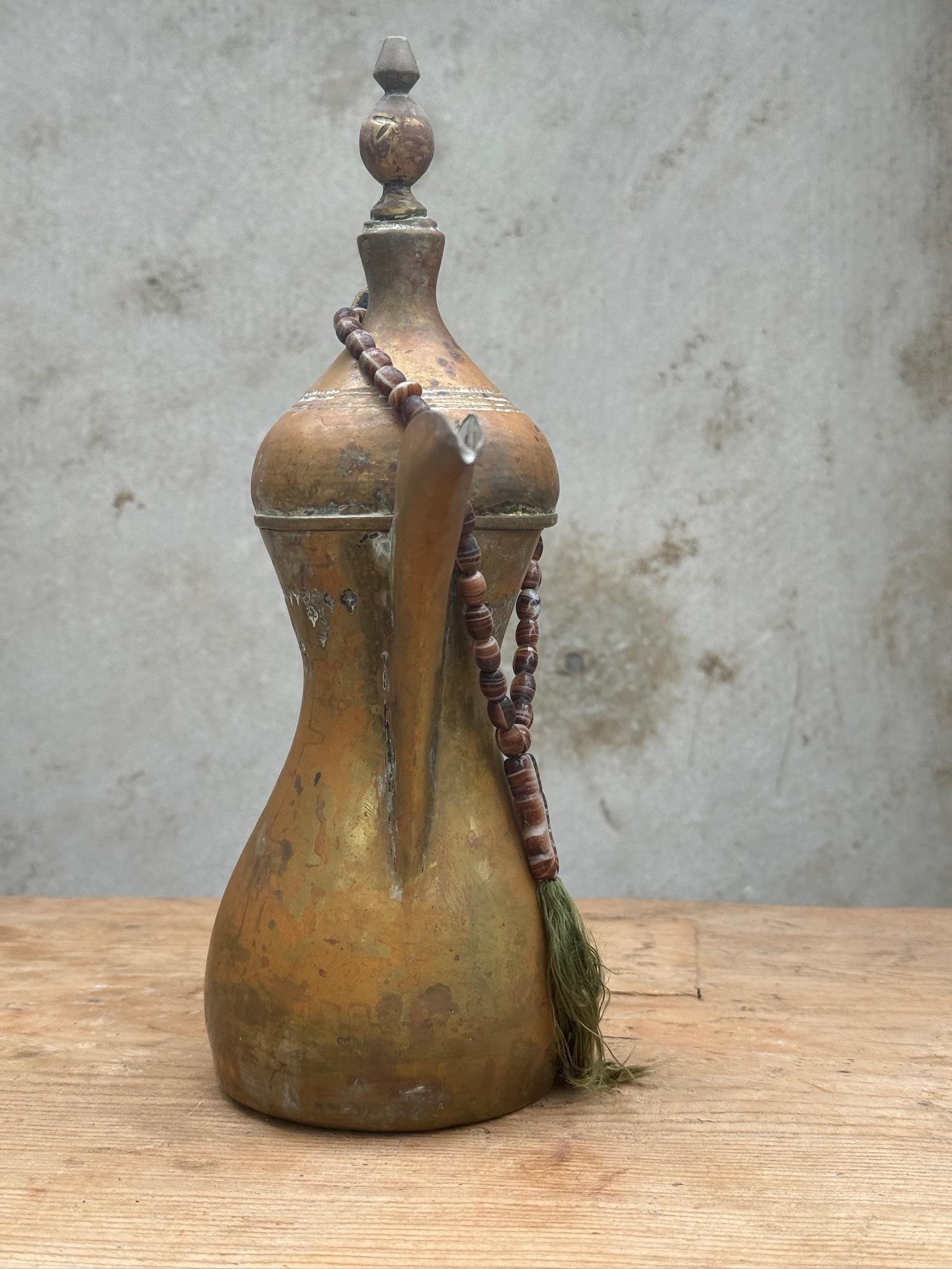 This is a traditional brass pot from the Middle East, used for brewing and serving Arabic coffee, or 
