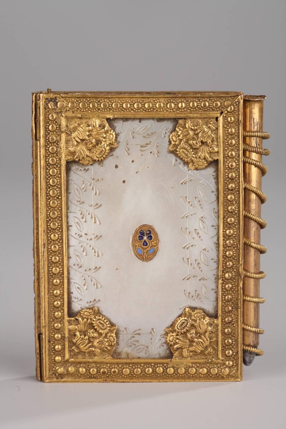 Charles X dance card in mother of pearl with gilt bronze mounts. It is engraved with plants, flowery interlacing, and bouquets of flowers. An enameled pansy adorns the cover, a typical motif of Palais-Royal objects. It has its original paper and