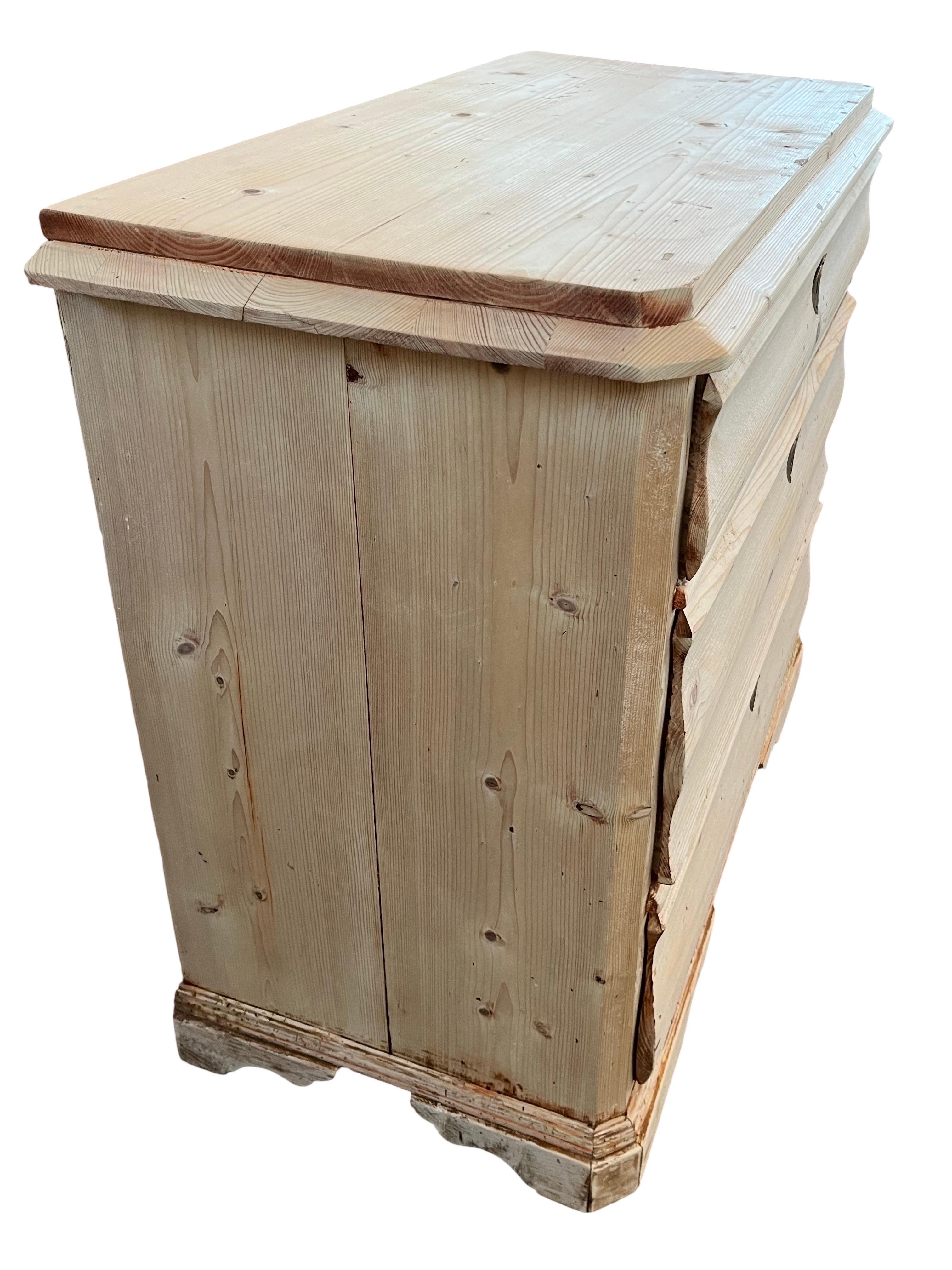 Biedermeier Kommode, die in Dänemark Anfang des 19. Jahrhunderts aus Kiefernholz handgefertigt wurde. Die Kommode hat drei übereinanderliegende Schubladen mit schönen, handgefertigten Schwalbenschwanzverbindungen und geschwungenen Schubladenfronten.