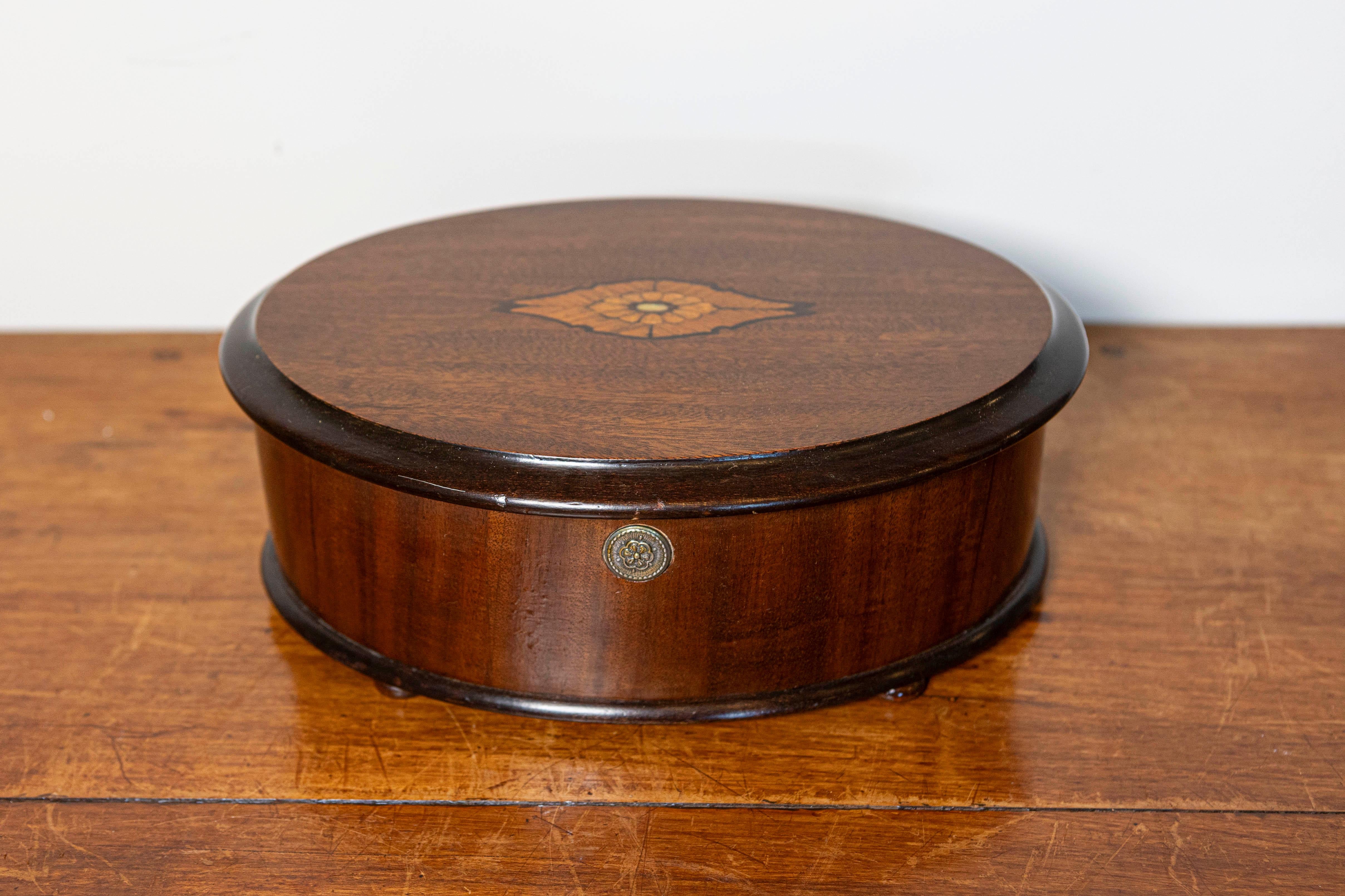 This elegant 19th-century Danish box, circa 1880, is an exceptional example of refined craftsmanship. Its round, curved shape is crafted from richly polished mahogany, highlighting the wood’s warm tones and striking grain. The lid features an inlaid