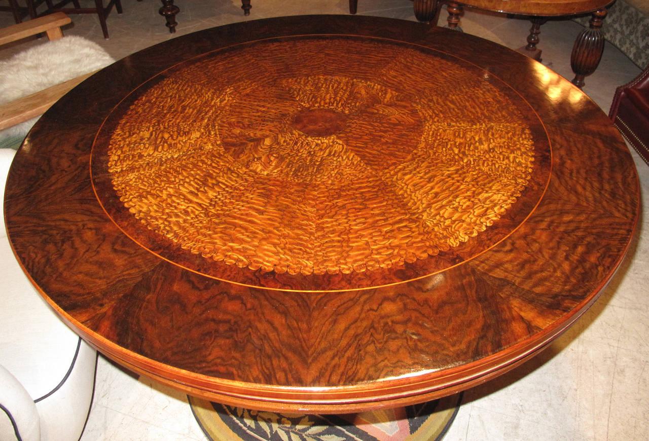 19th century Danish center table with a fine root wood inlaid top. The molded edge top is inlaid with concentric inlays of contrasting burled root wood and is on a fluted base ending in a circular base uniquely mounted with needlepoint, an