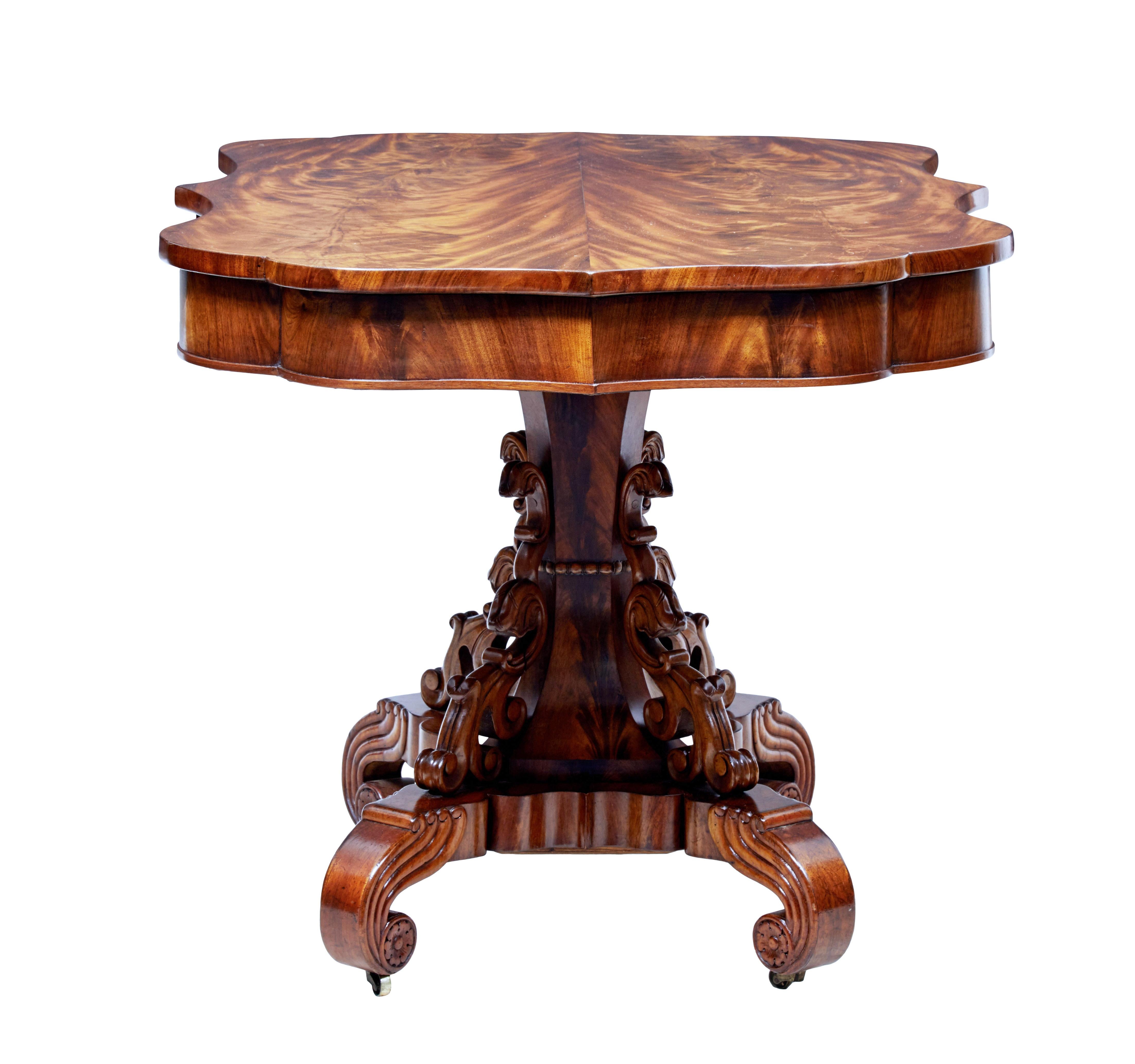 Stunning mid-19th century Danish mahogany centre table, circa 1860.

Beautifully shaped top surface with striking half matching veneer top. Standing on a fluted stem with applied pierced carvings. Standing on a quadriform shaped base and carved