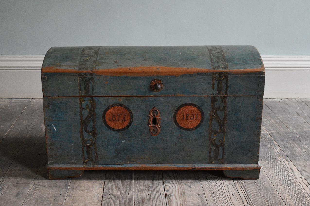 Swedish Hand Painted Domed Top Trunk

Iron, pine, paint, metalwork. A Swedish 19th-century hand-painted dome top dowry trunk with its original blue paintwork. The facade depicts the initials 'BTA' along with the date, 1801, and further decorative