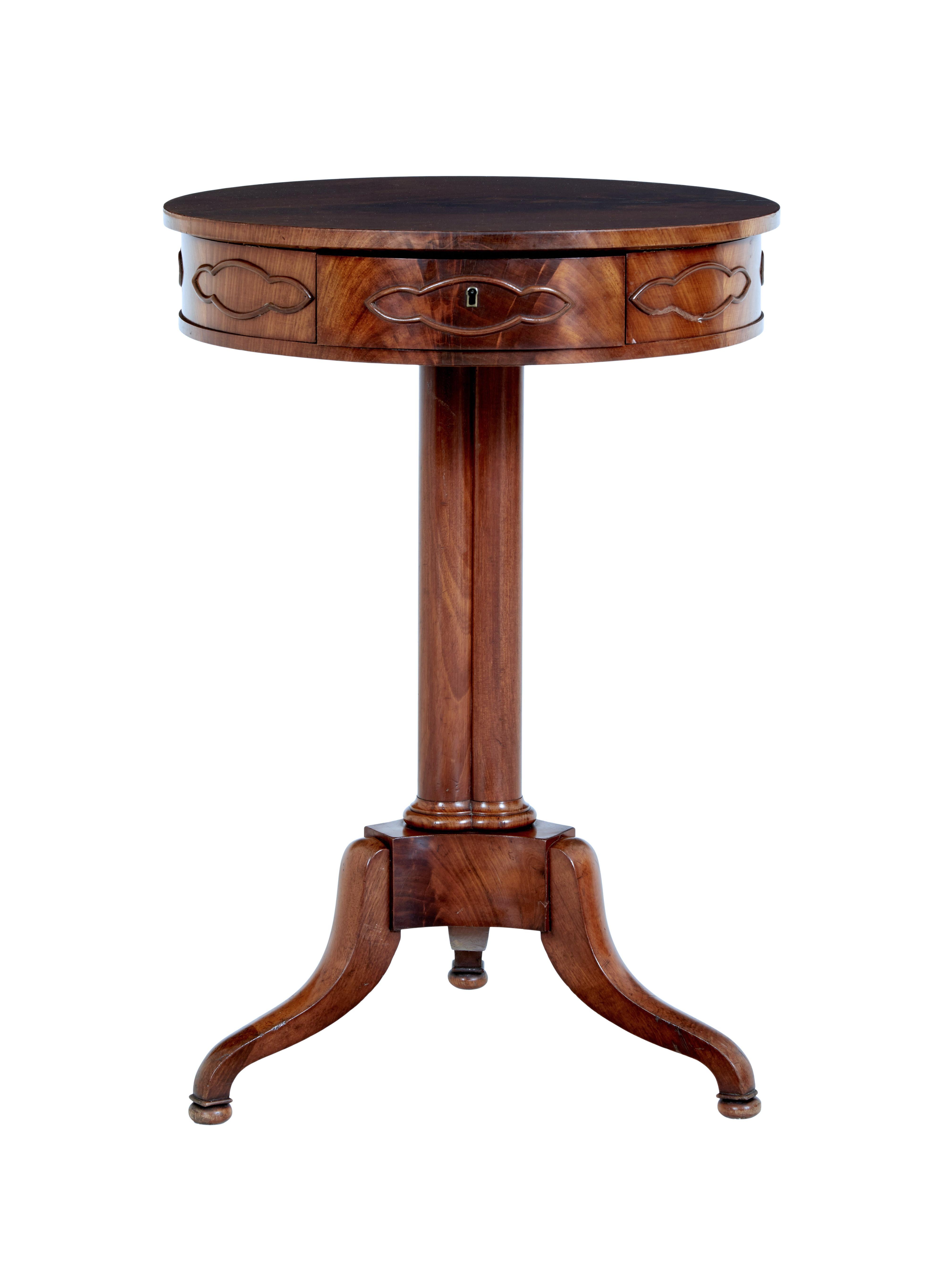 Elegant piece of danish 19th century design circa 1860.
One piece mahogany top, below which is a single fitted drawer, with compartments and hidden pin cushion. Applied detailed molding around the top.
3 column stem, standing on tripod