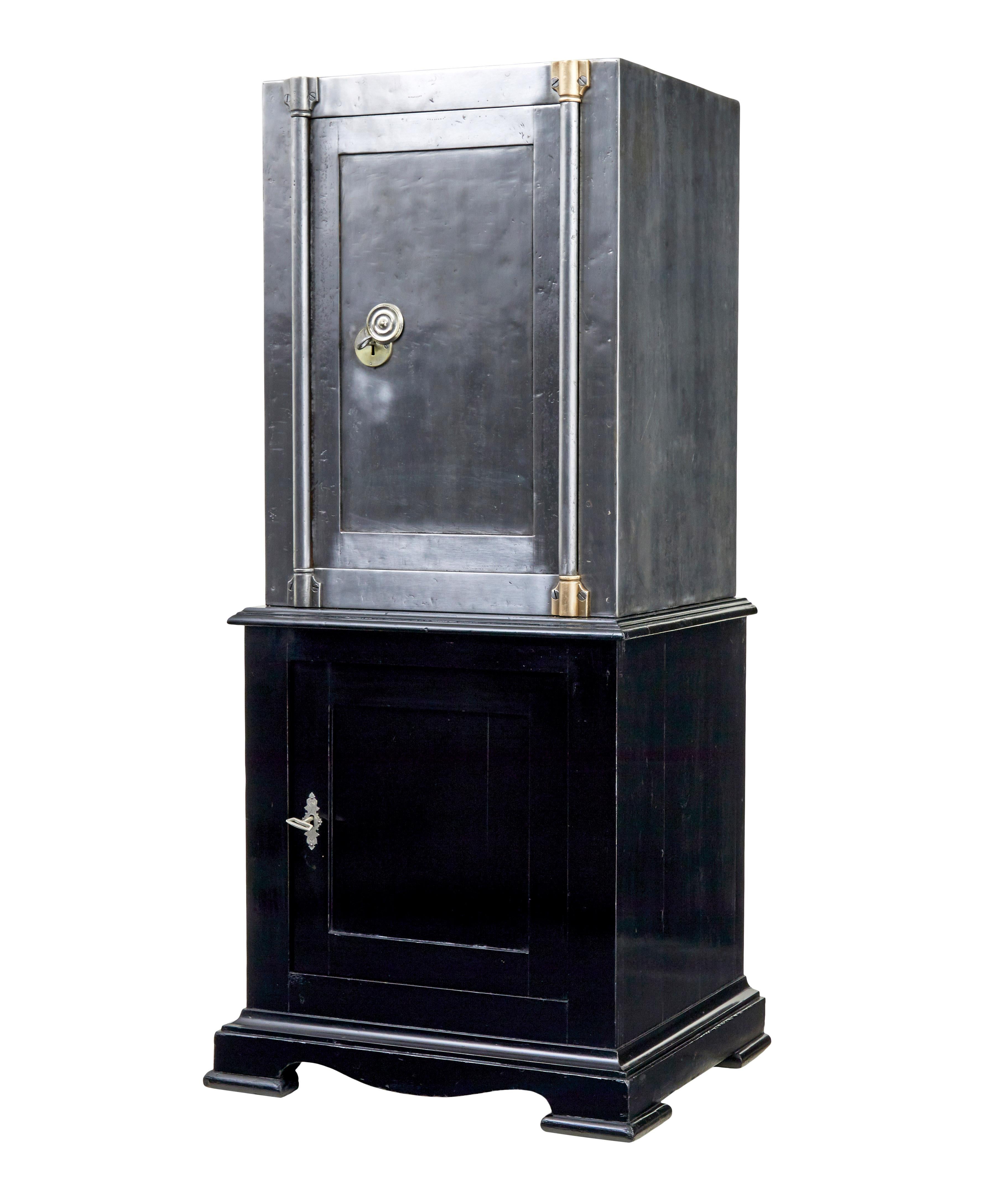 19th century Danish polished steel safe on stand circa 1890.

Fine quality Danish solid steel safe on lacquered pine base cabinet.  Metalwork has been stripped back to reveal the polished steel surface.  Door opens on the key to reveal the original