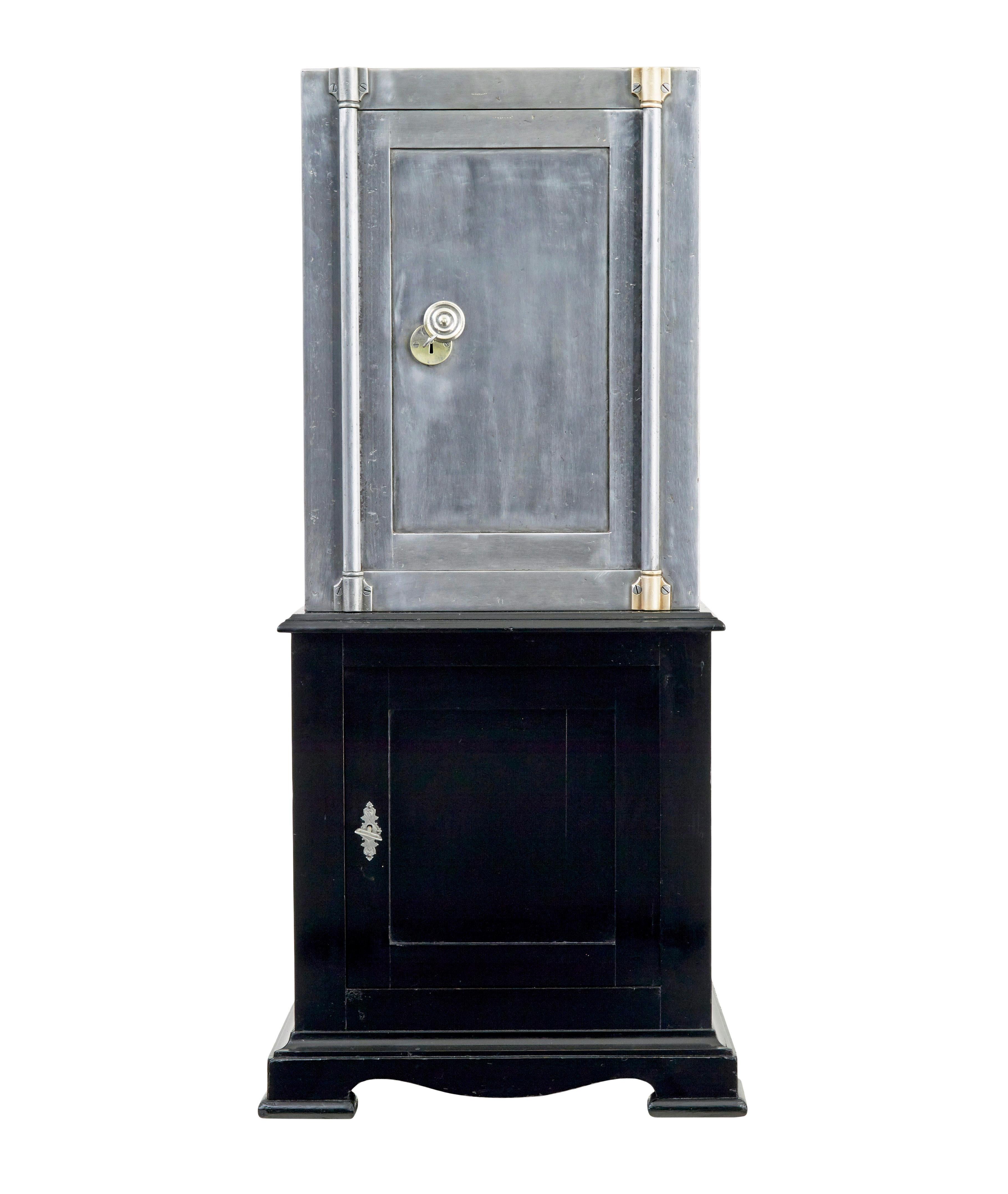 19th century Danish polished steel safe on stand circa 1890.

Fine quality danish solid steel safe on lacquered pine base cabinet.  Metalwork has been stripped back to reveal the polished steel surface.  Door opens on the key to reveal the original