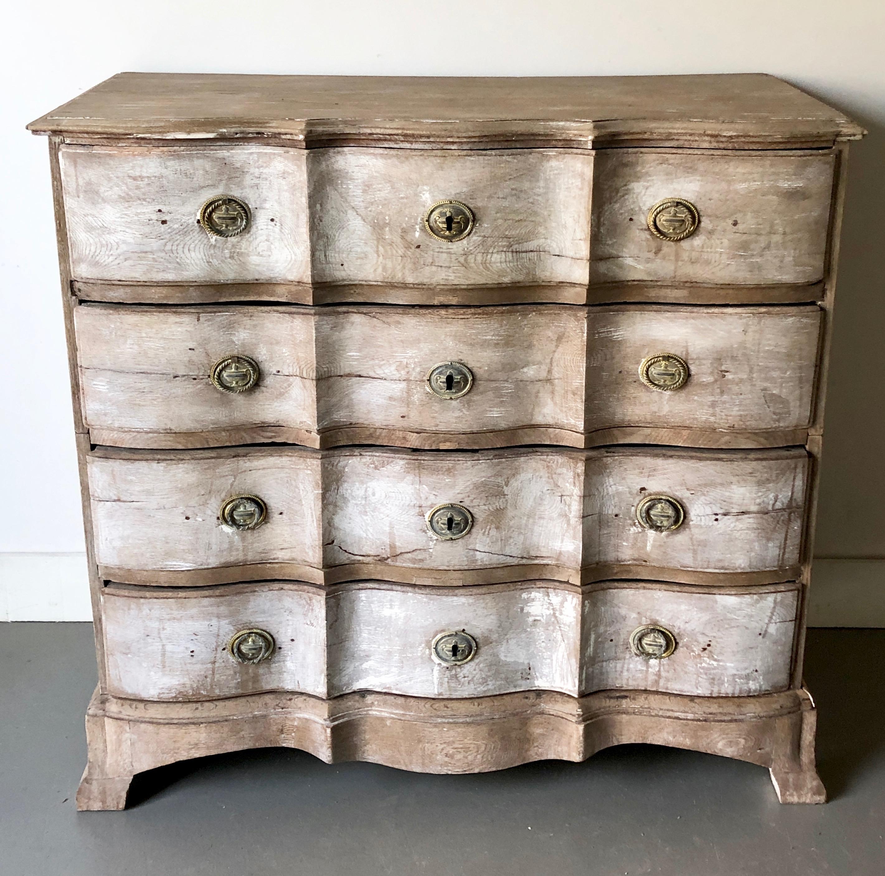 An exceptional, very large 19th century Danish serpentine front chest in bleached oak with some fragment white paint. Beautifully carved serpentine drawers with original handsome bronze escutcheons. The chest is in two parts for convent