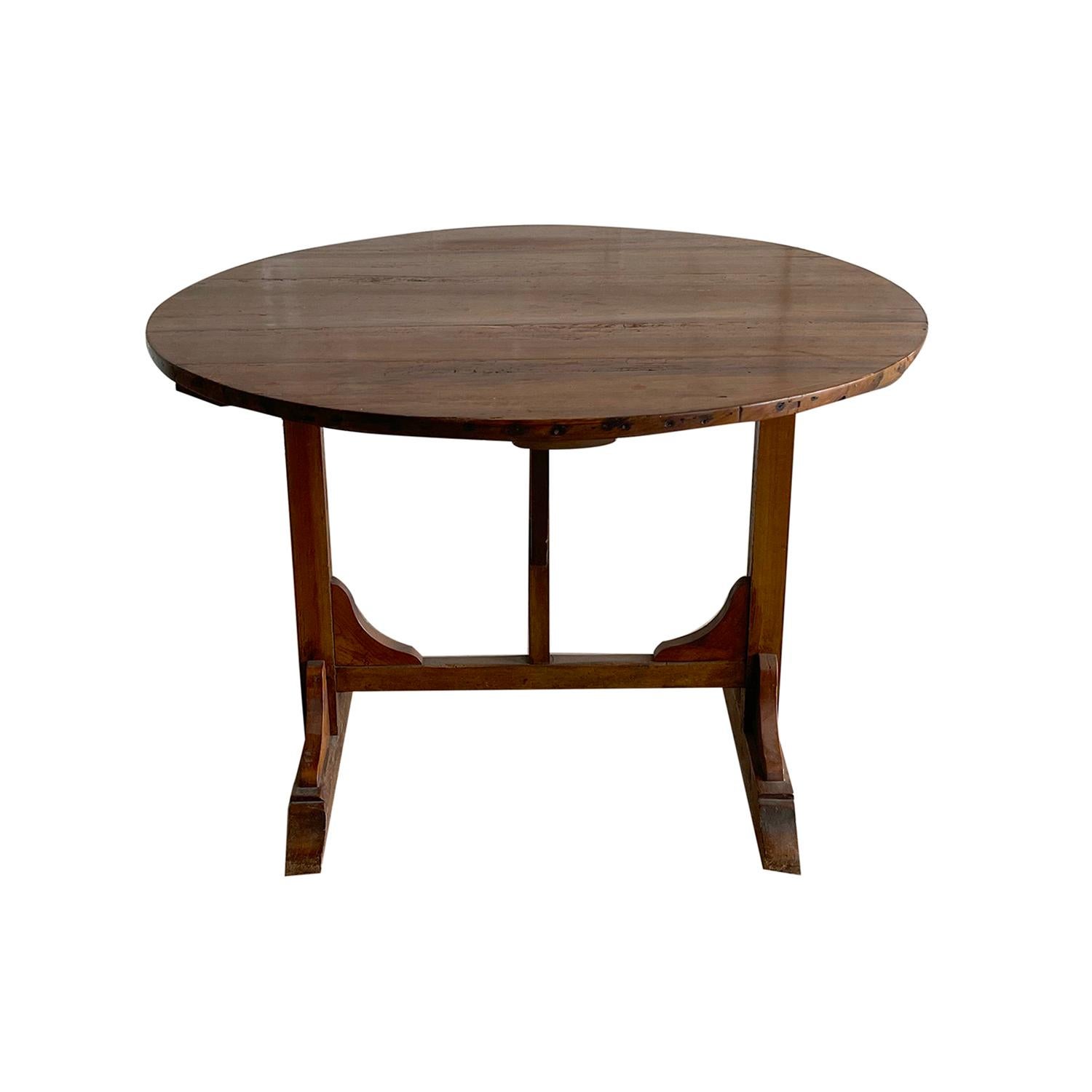 An antique round French wine folding table made of hand carved Walnut, in good condition. The Vigneron tables are used in France as occasional tables in wine cellars. Wear consistent with age and use. Circa 1880, France.